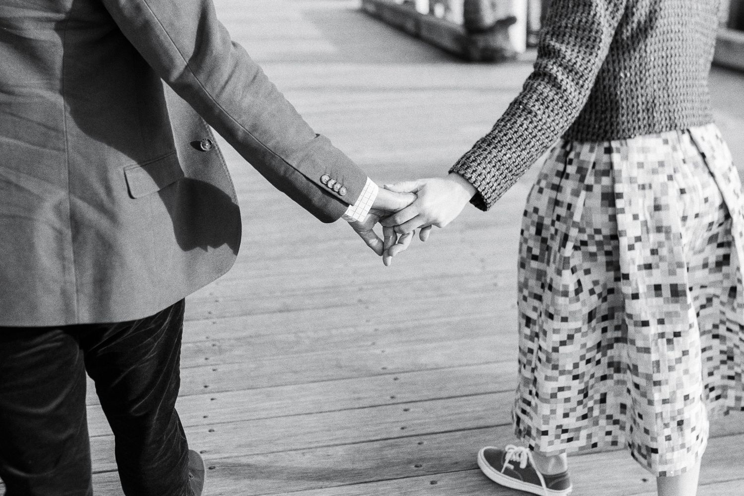 Black and white sequence showing couple holding hands in casual attire.