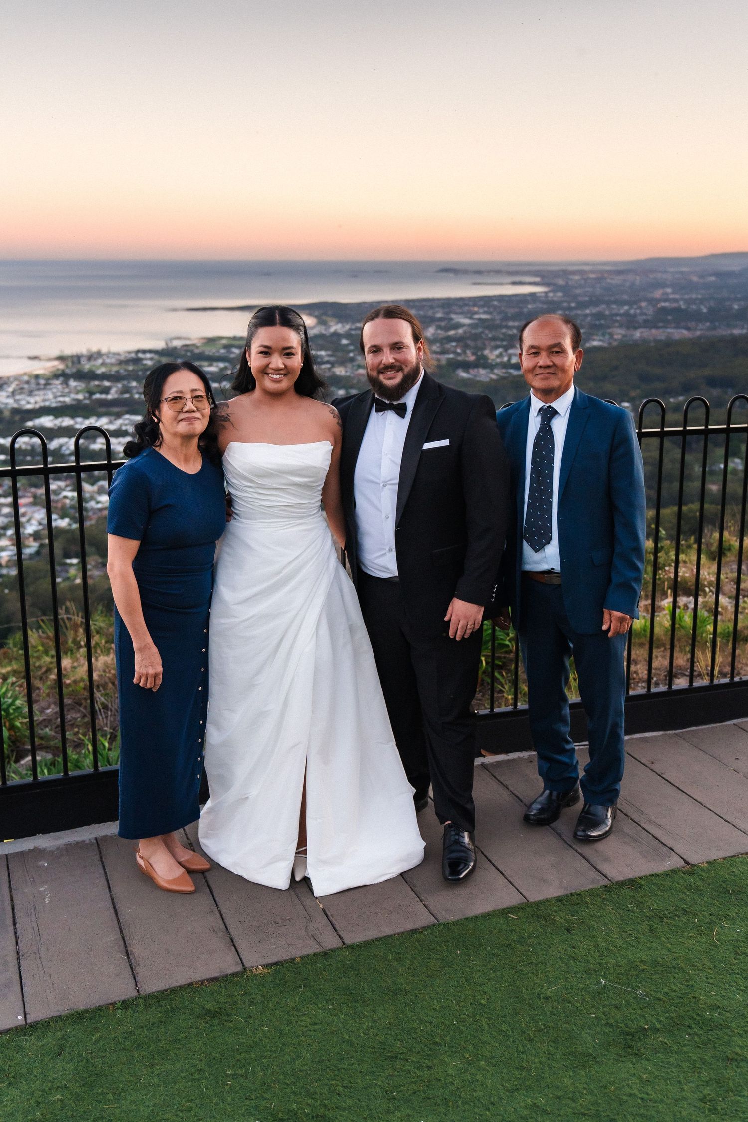 Wedding group photo at scenic overlook during golden hour.