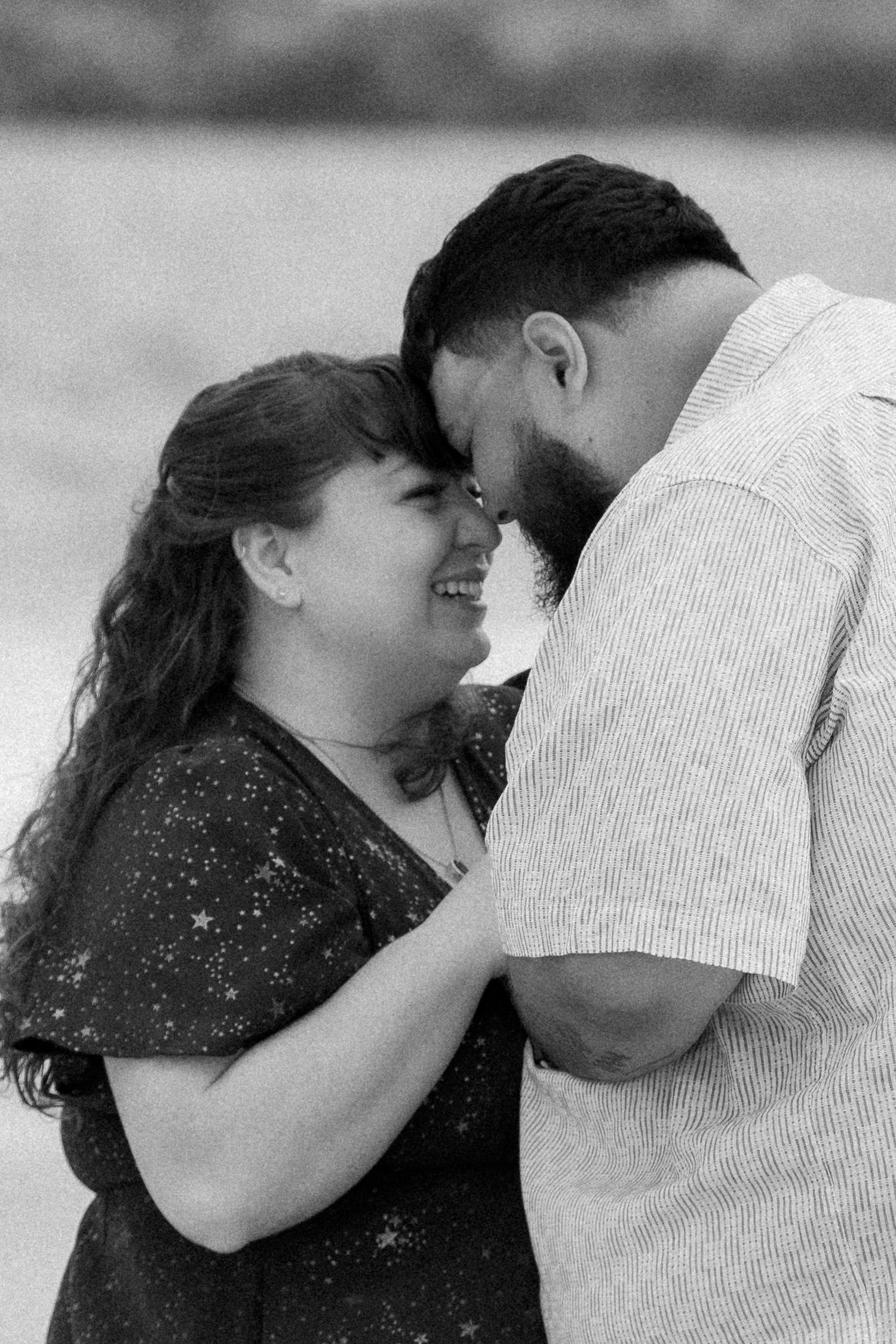An intimate black and white portrait series showing tender moments between a couple.