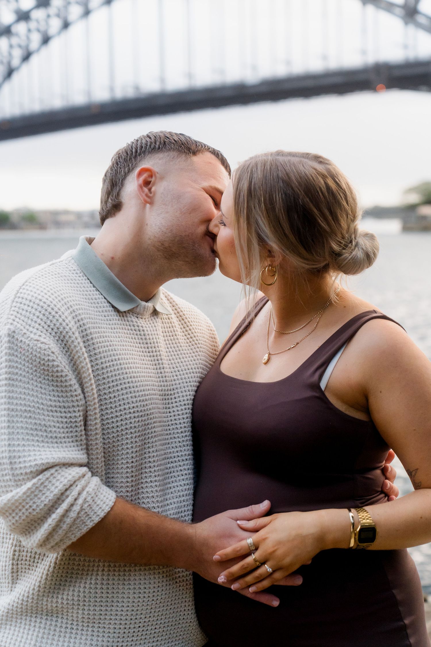 A romantic moment shared between a couple with the Sydney Harbour Bridge in view.