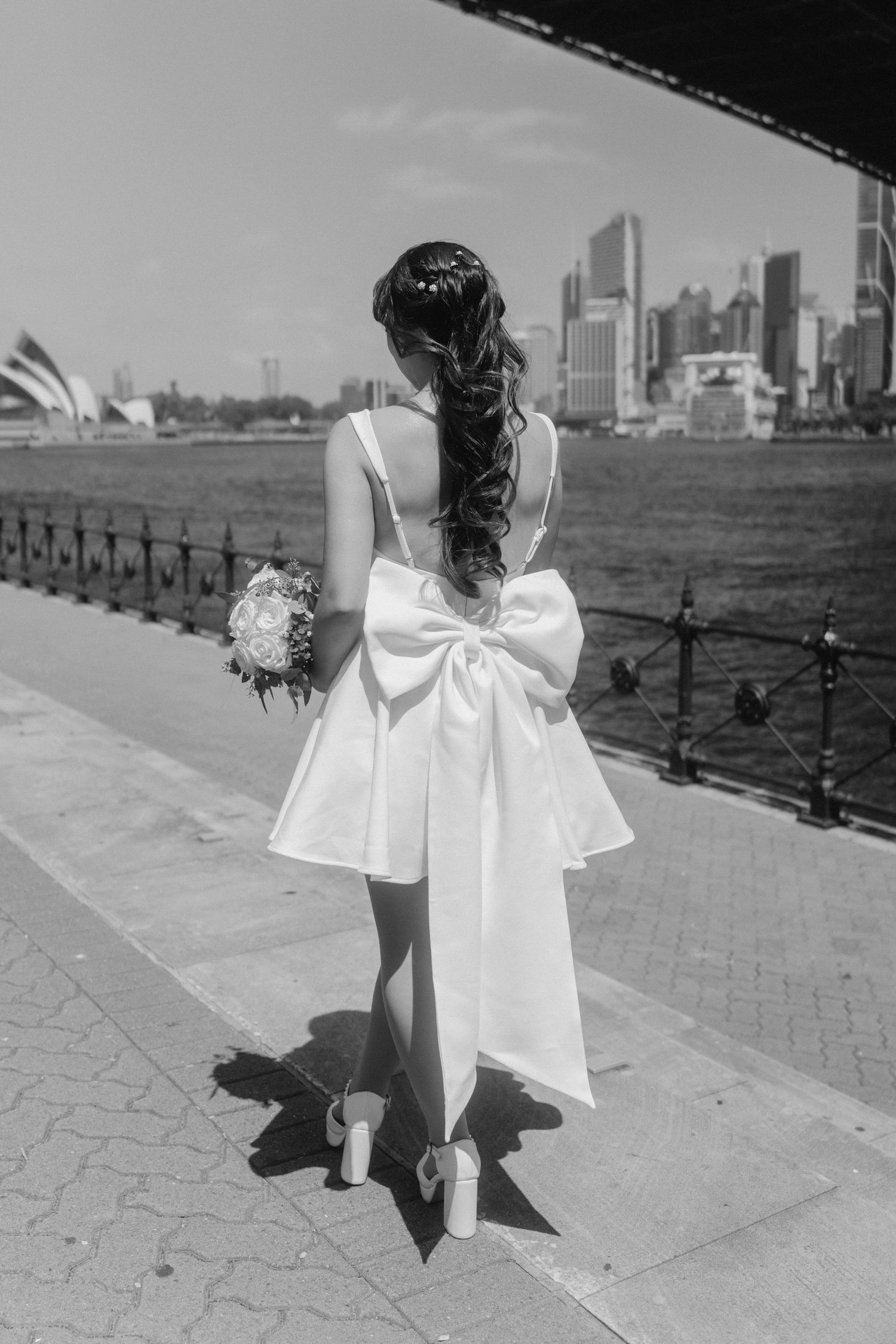 Black and white photos of a bride walking along Sydney Harbour.