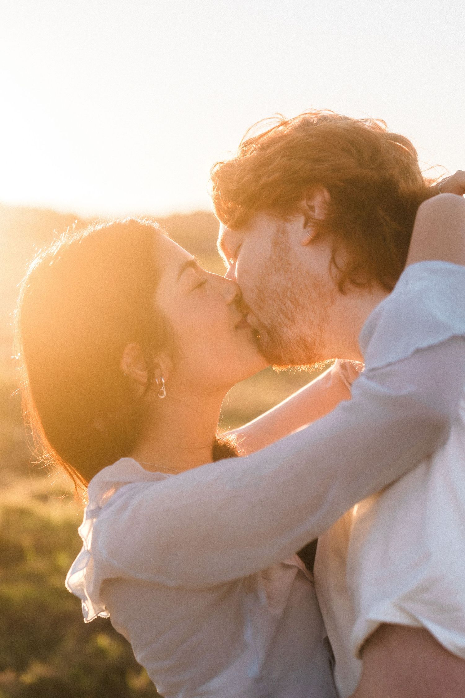 A romantic sunset embrace with golden light filtering through.