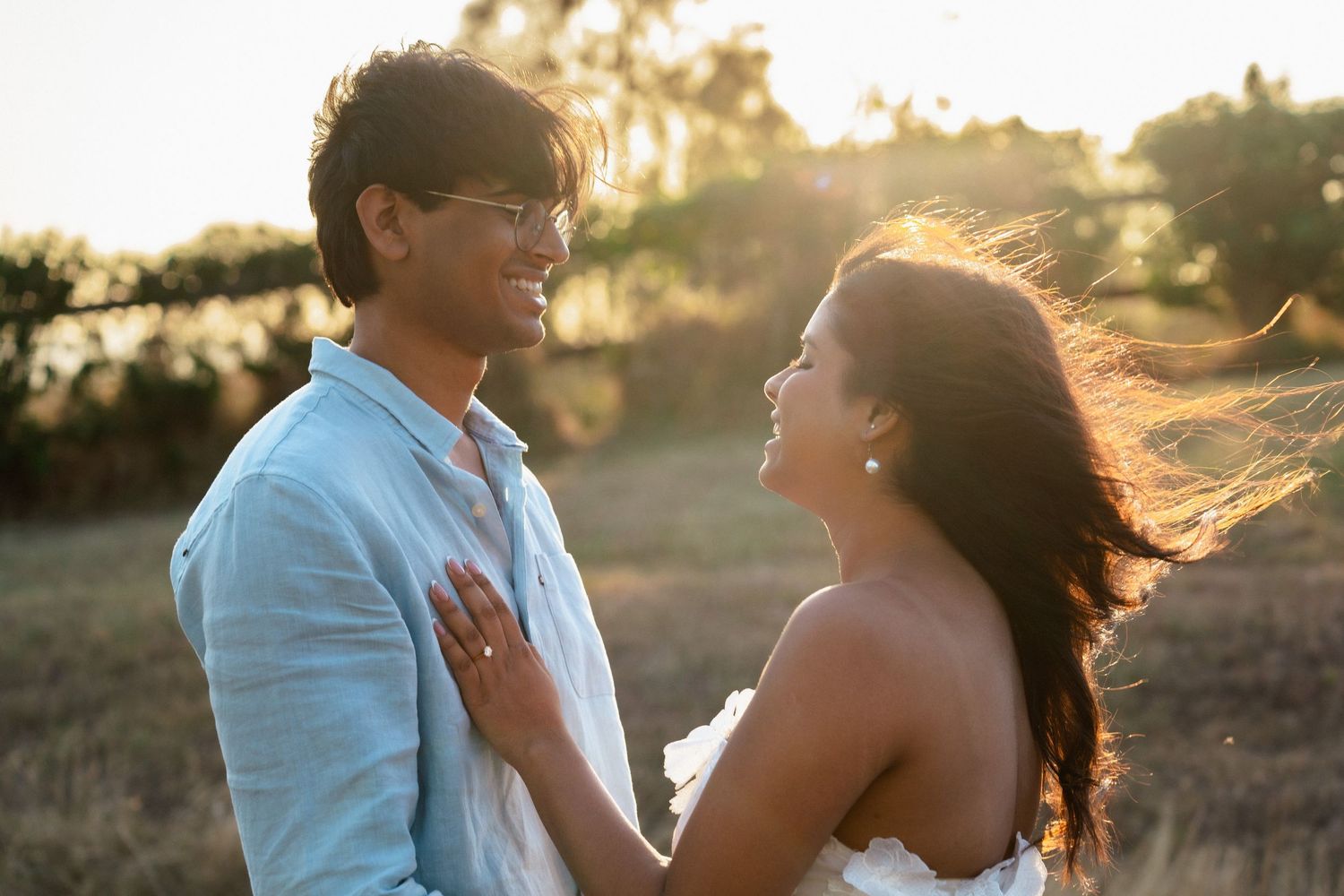 Romantic sunset photoshoot with couple silhouetted against golden light.