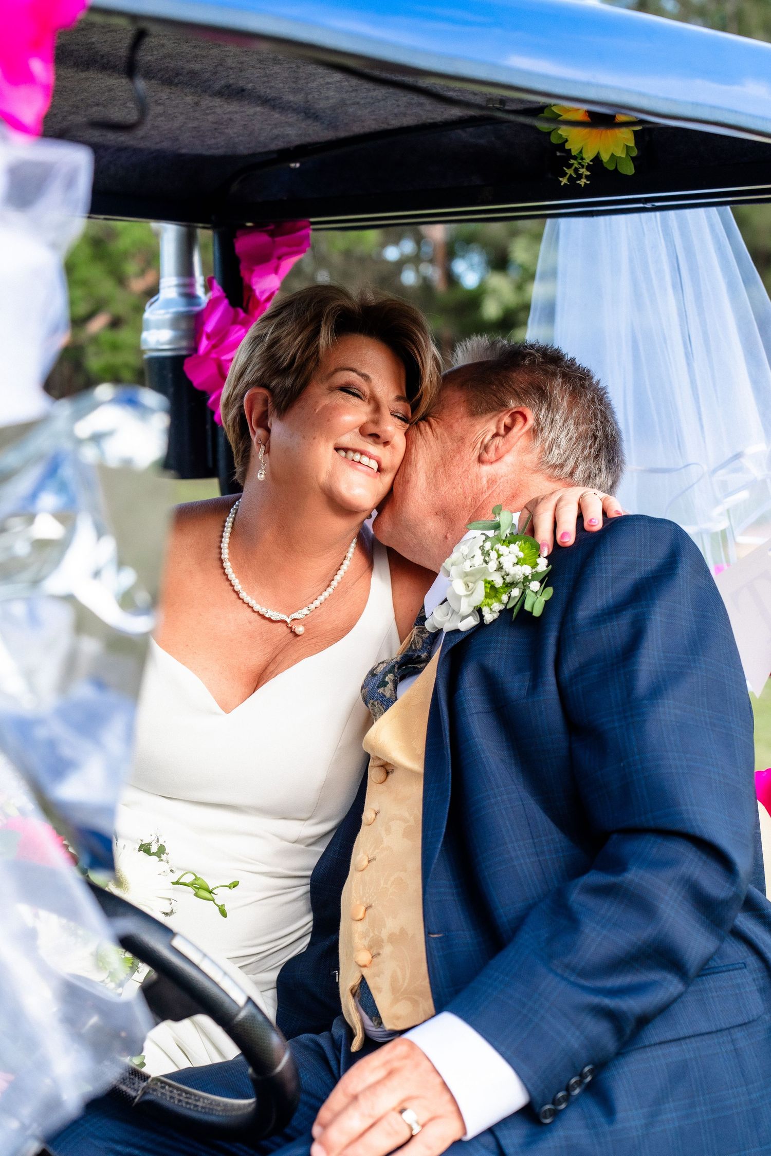 Romantic wedding couple sharing tender moments under a decorated canopy.
