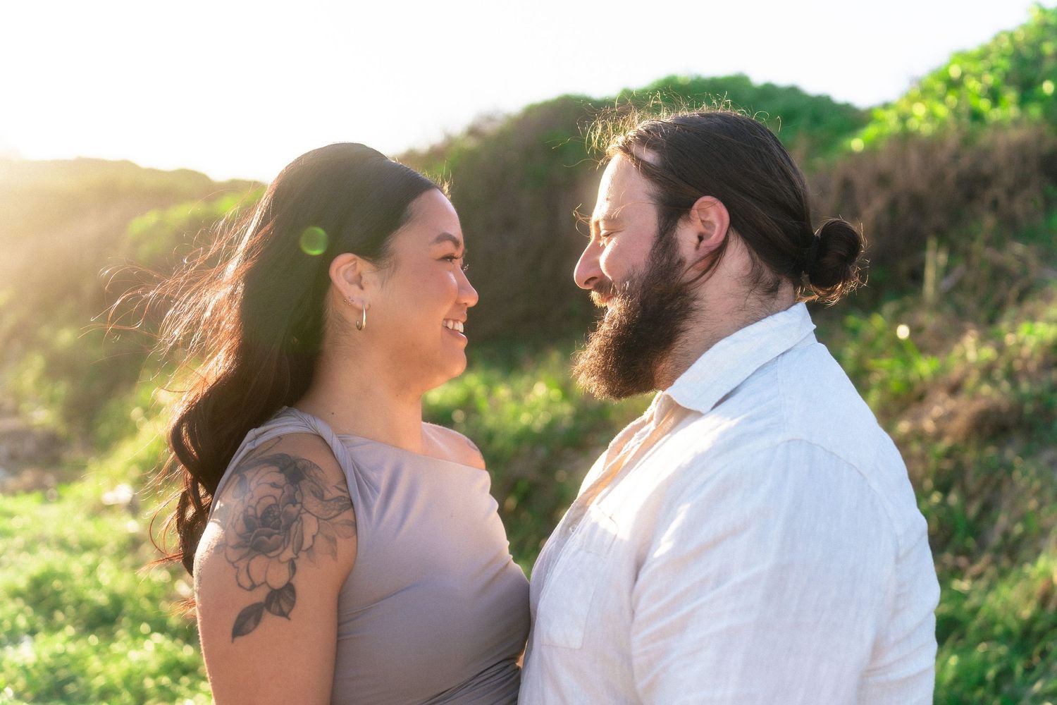 A couple shares an intimate moment during golden hour outdoors.