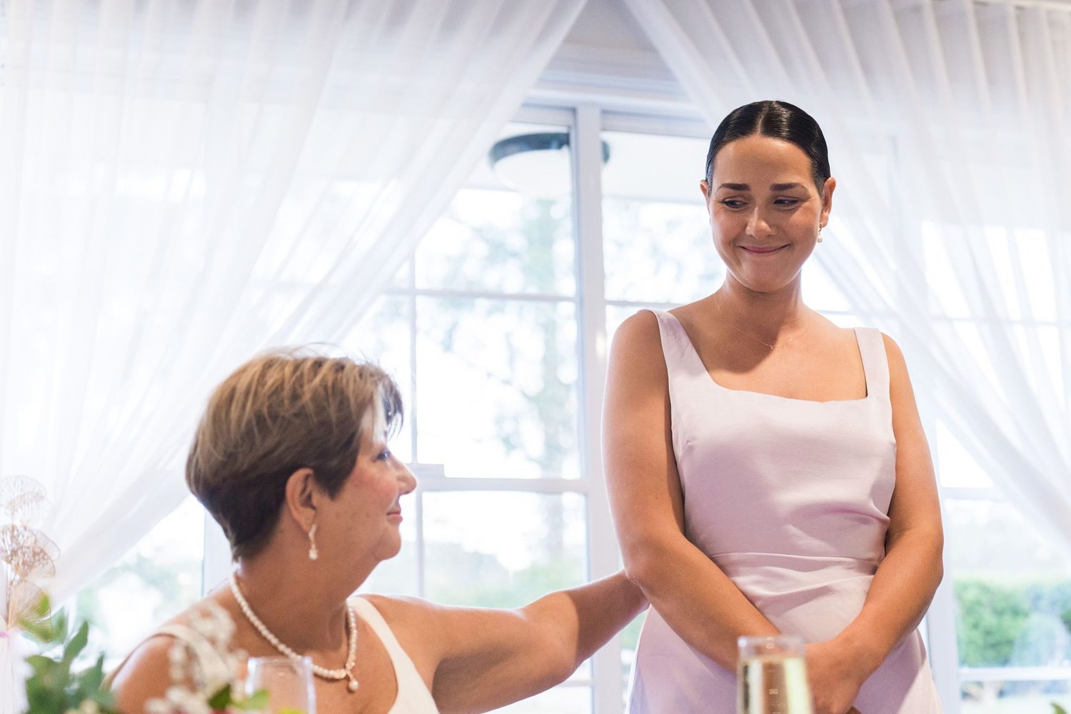 Indoor wedding venue with white drapes and elegant table settings.