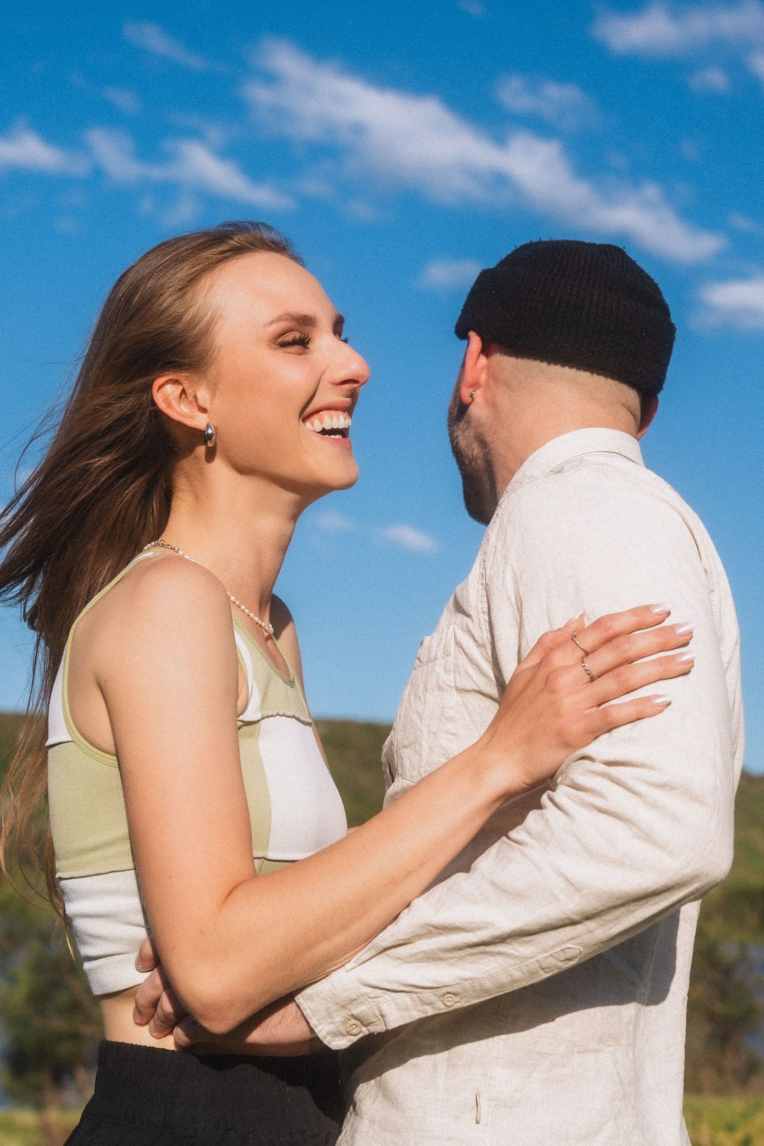 A series of affectionate moments captured against a vibrant blue sky background.