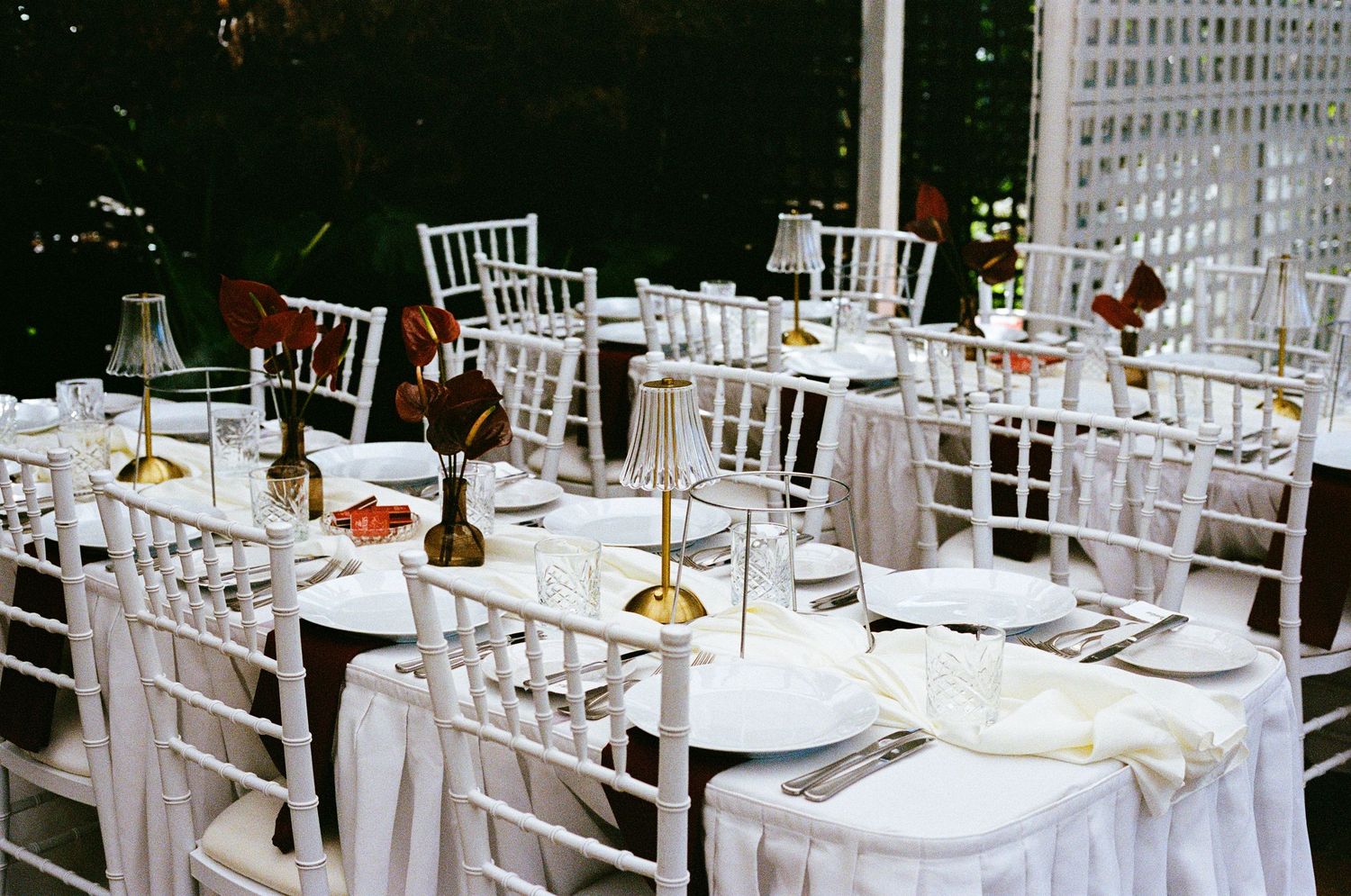 Elegant wedding reception setup with white Chiavari chairs and formal table settings.