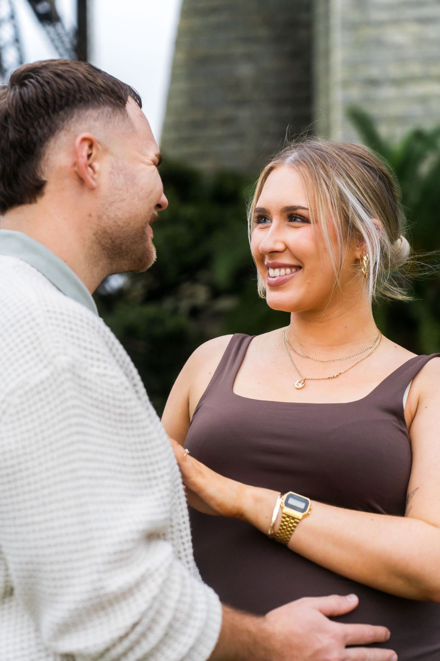 A couple shares playful moments outdoors in casual attire.