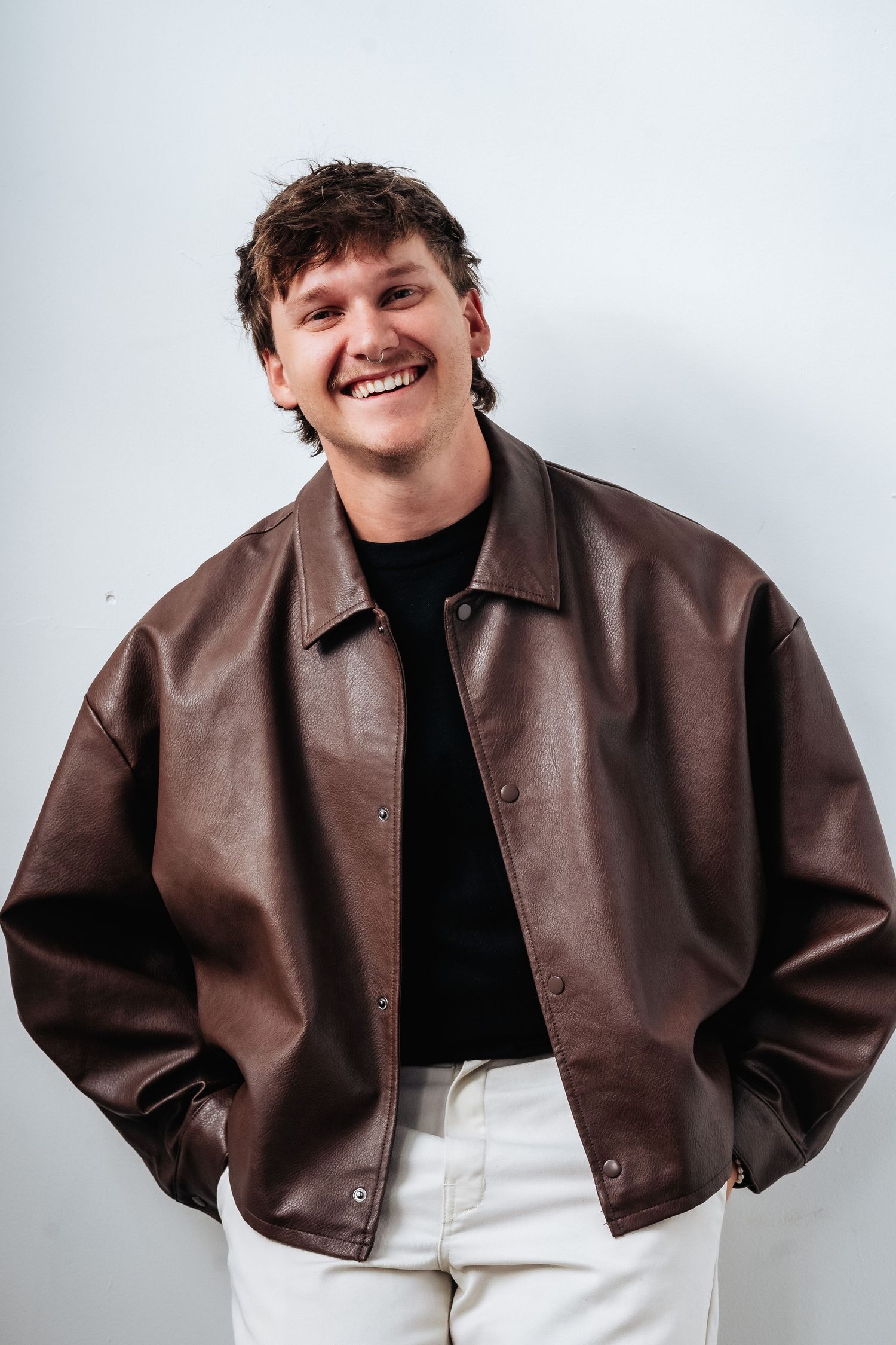 Candid fashion portraits showing a person in a brown leather jacket and black shirt.