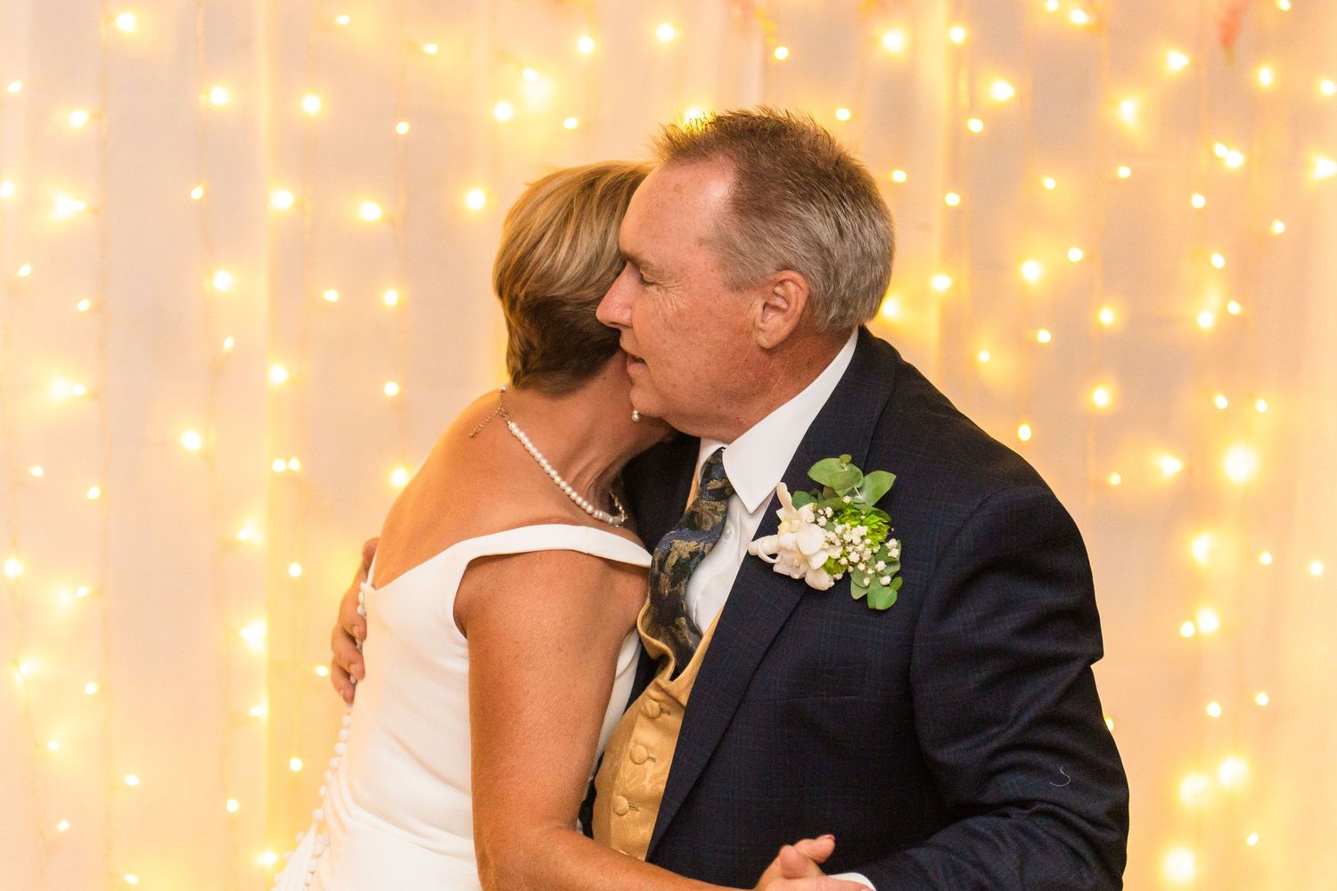 Romantic dance scene with twinkle light backdrop at wedding reception.