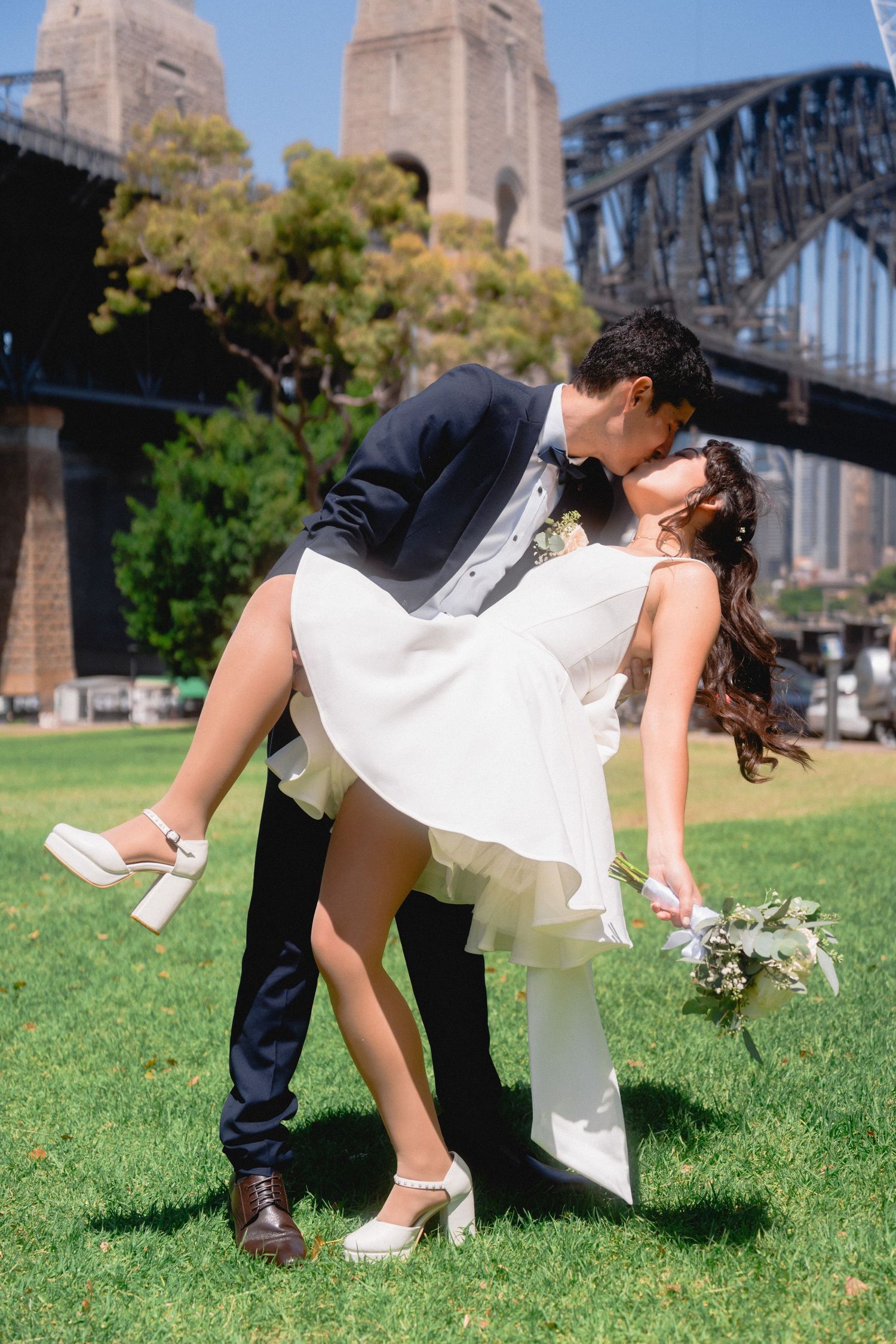 A romantic dip pose with the Sydney Harbour Bridge in the background.