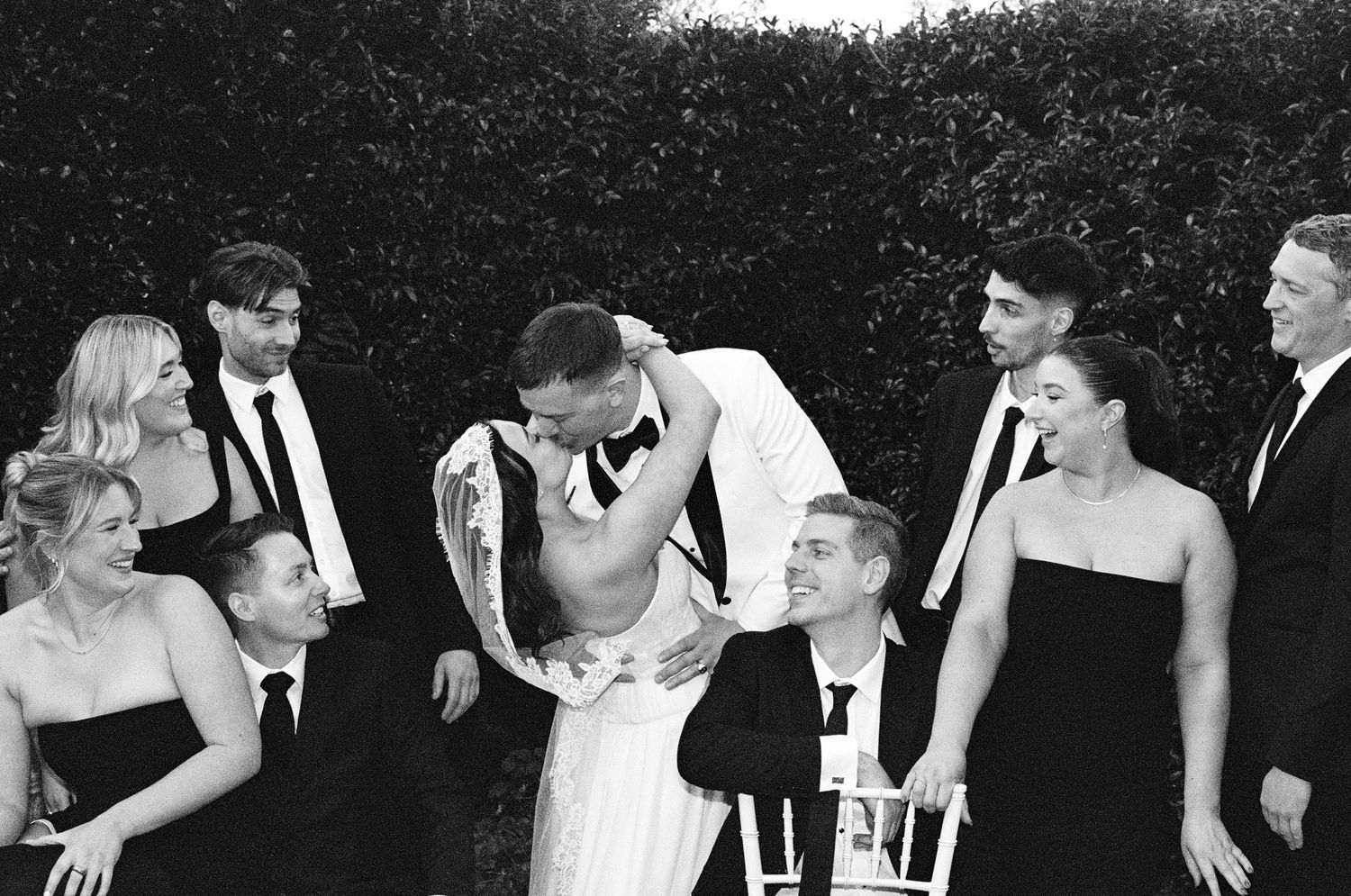 Black and white wedding party group photos showing joyful interactions.