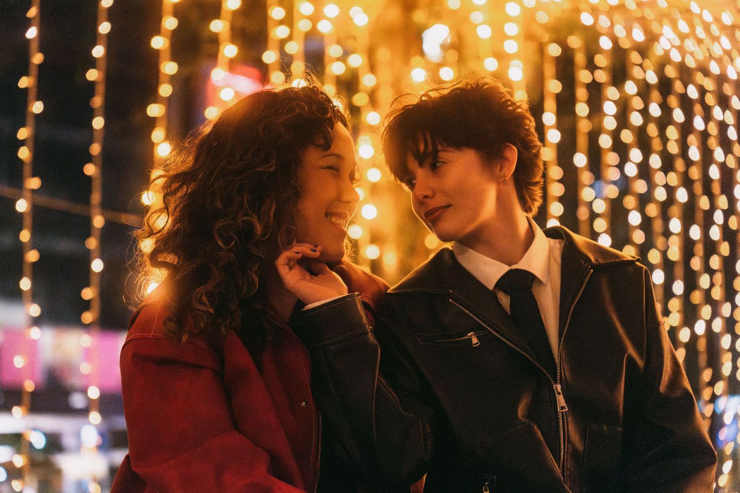 Romantic couple dancing under twinkling string lights at an evening celebration.