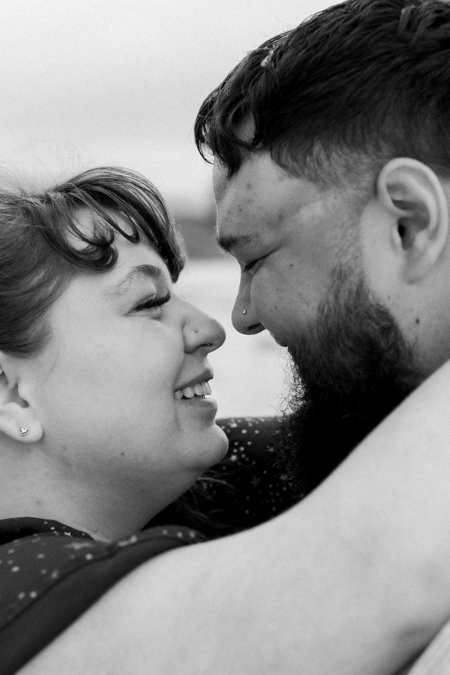 Intimate black and white close-up portraits of a couple sharing tender moments.