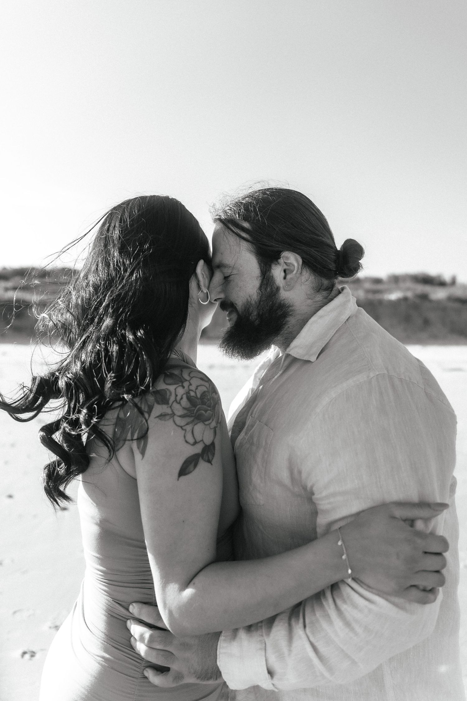 A black and white photo of an intimate beach embrace.
