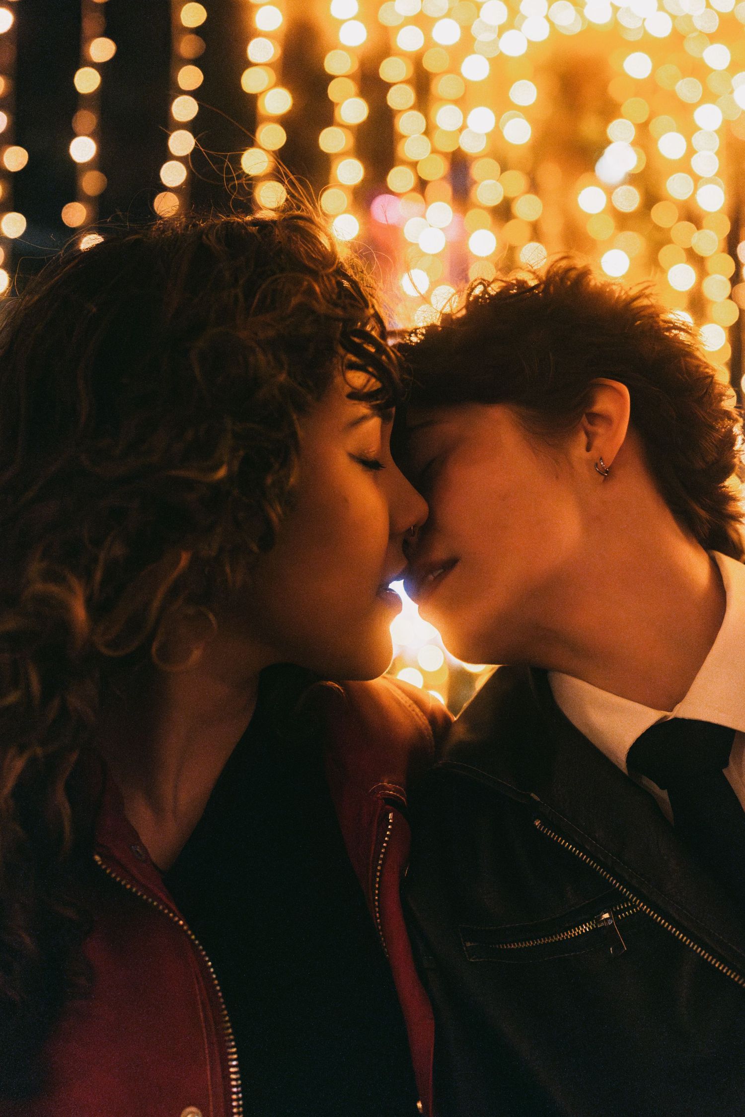 Two people share a moment against a backdrop of twinkling holiday lights.