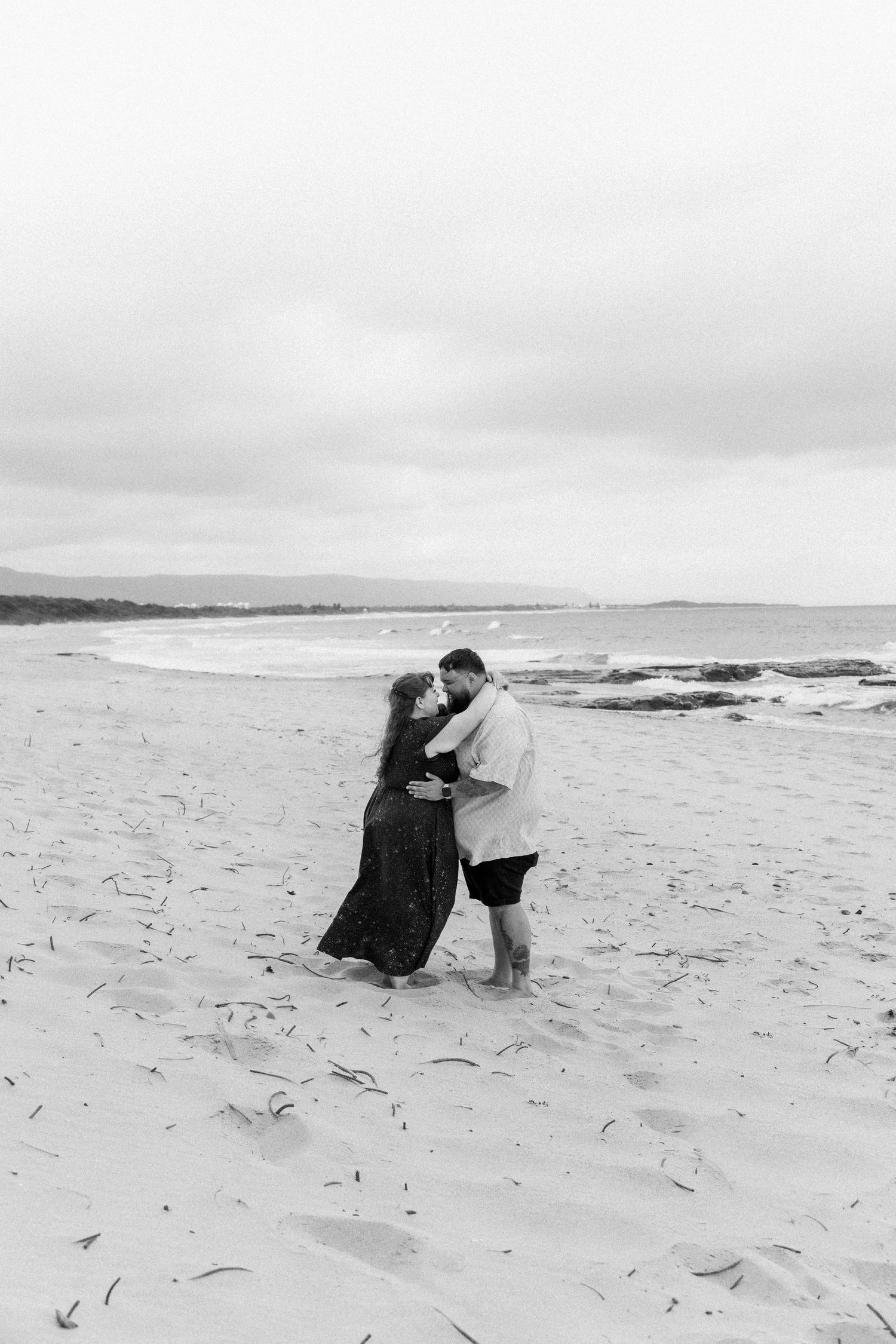 Couple playing and dancing together on a misty beach.