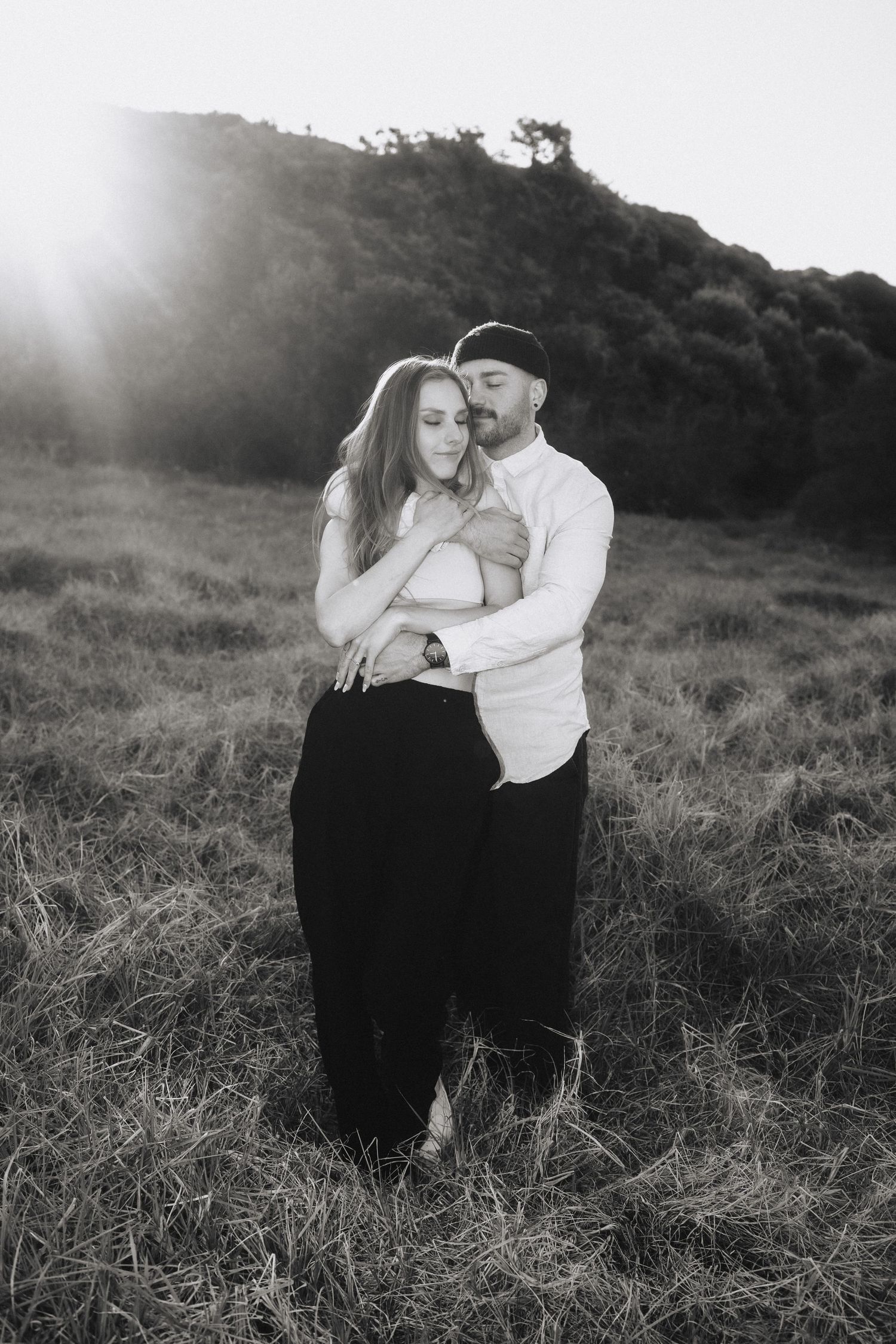 Atmospheric black and white portraits of a couple in an outdoor setting.