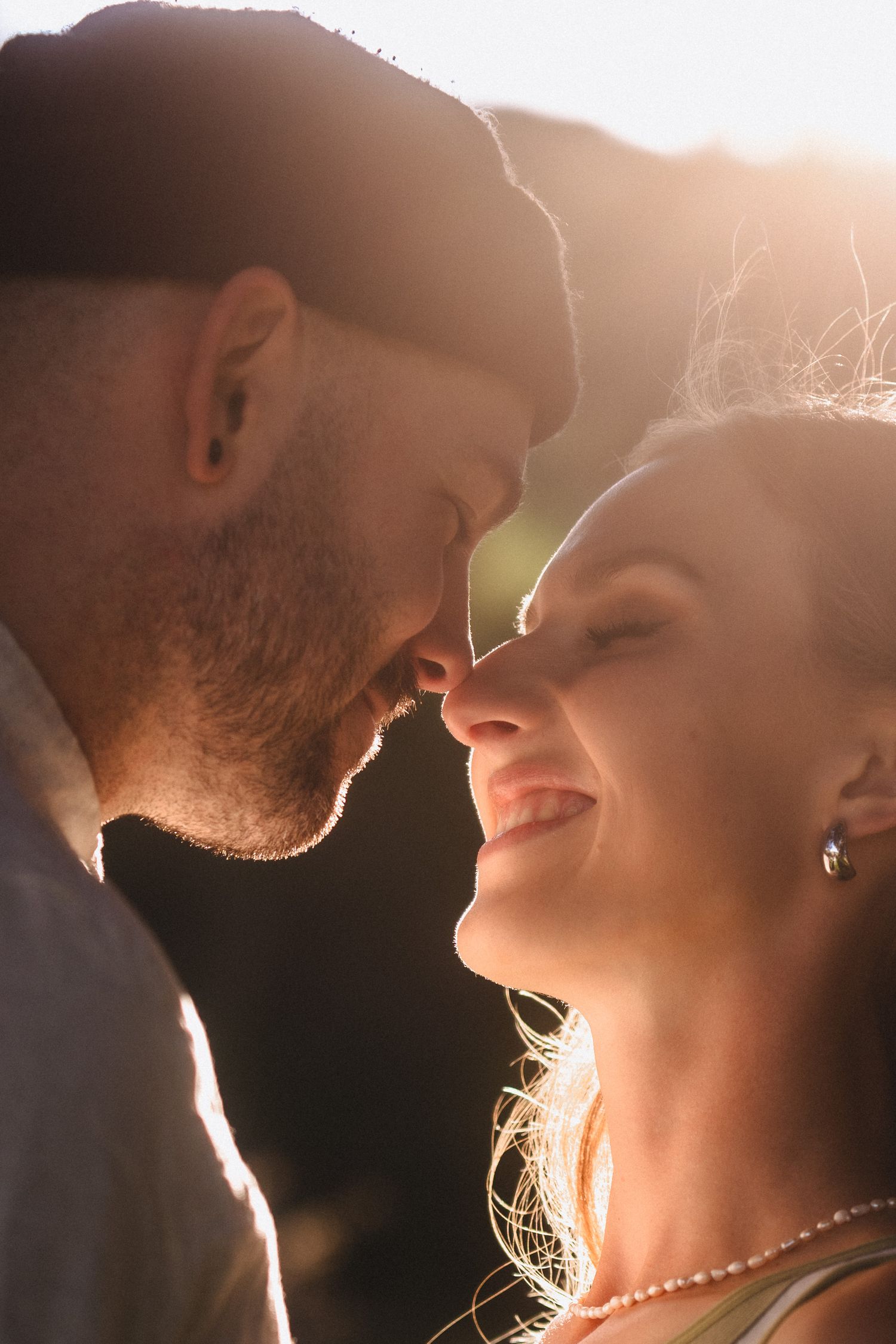 Romantic silhouetted couple sharing an intimate moment in golden sunlight.