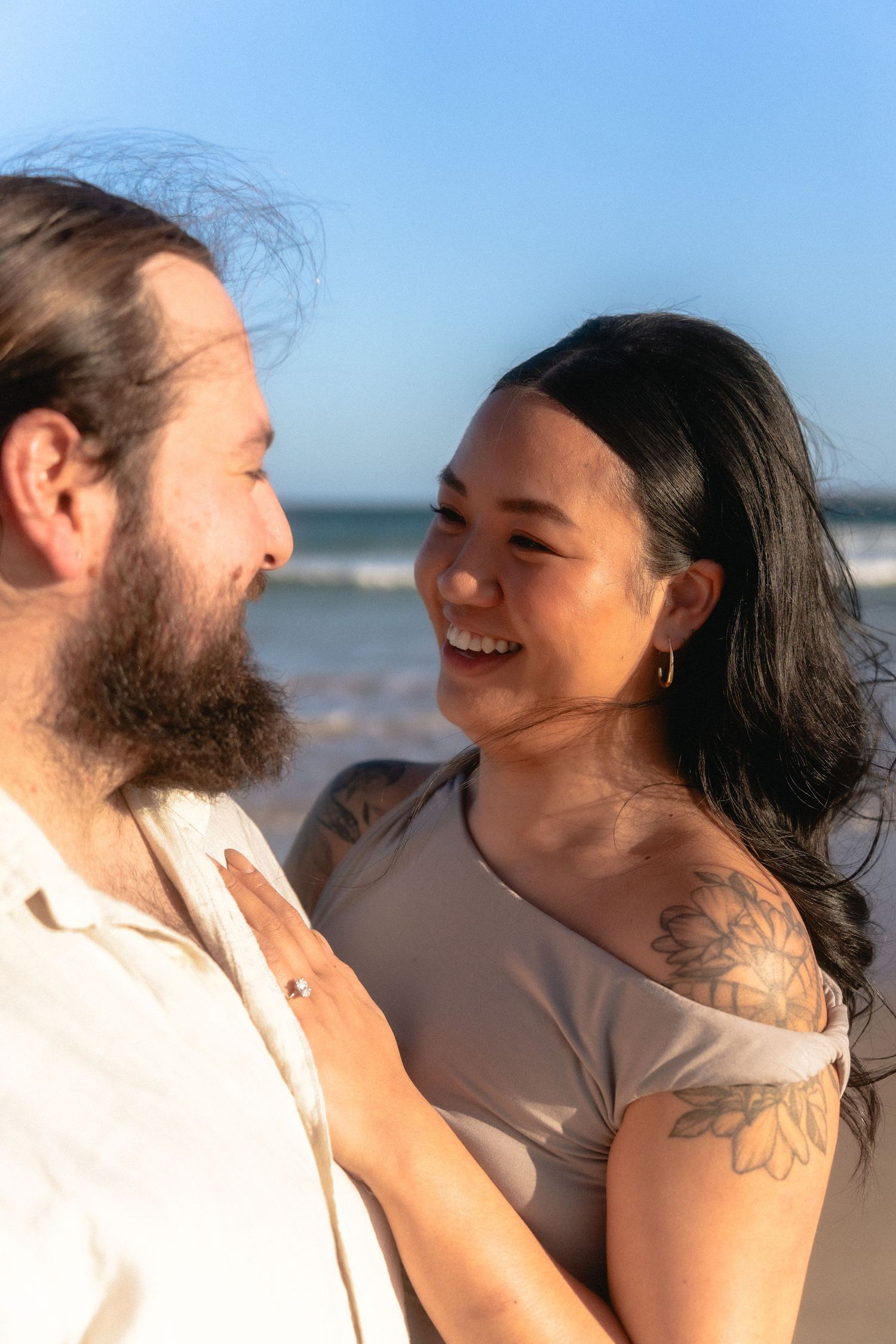 A couple laughs together during a casual outdoor photoshoot.