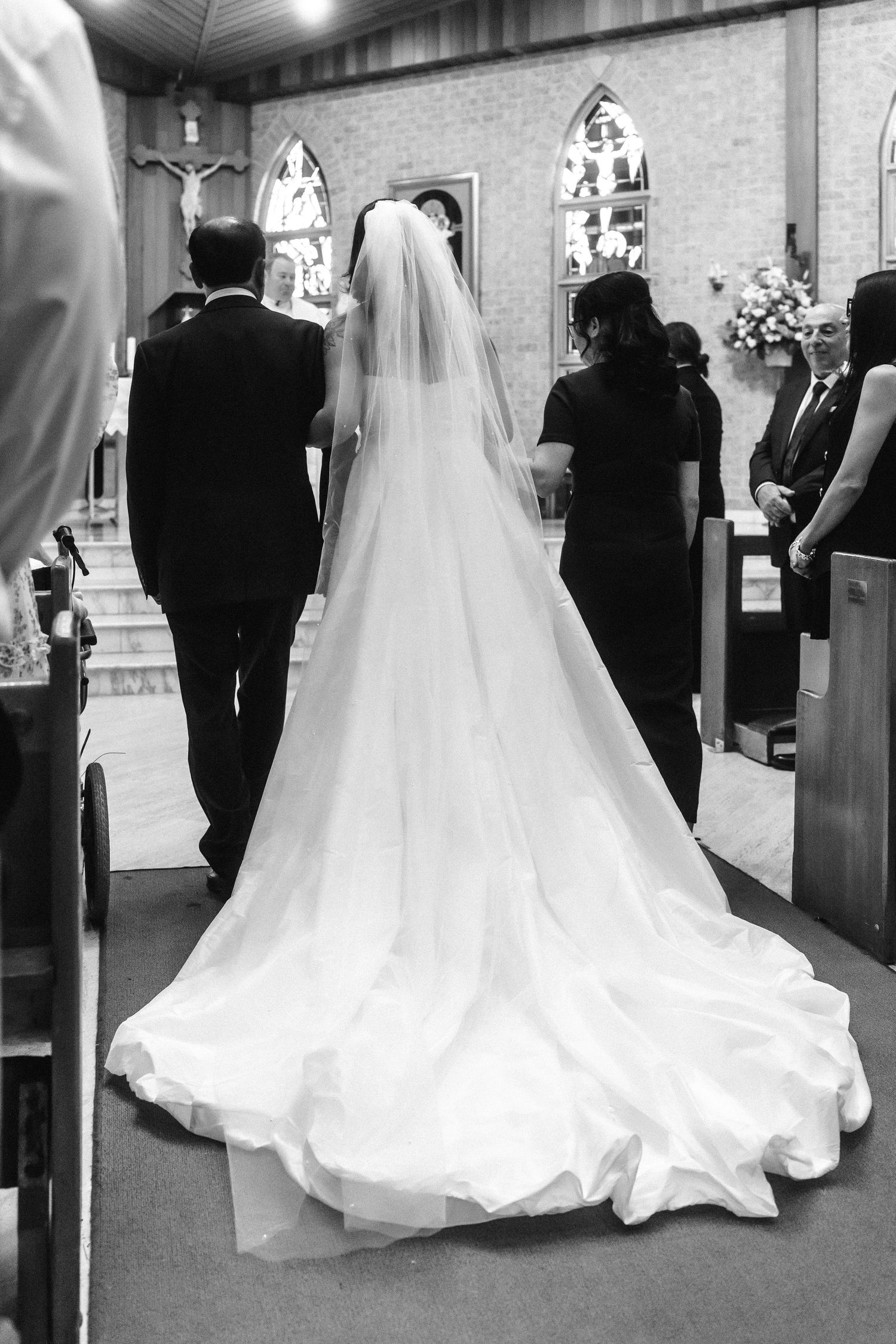 Wedding ceremony procession in a church with flowing white bridal gown.