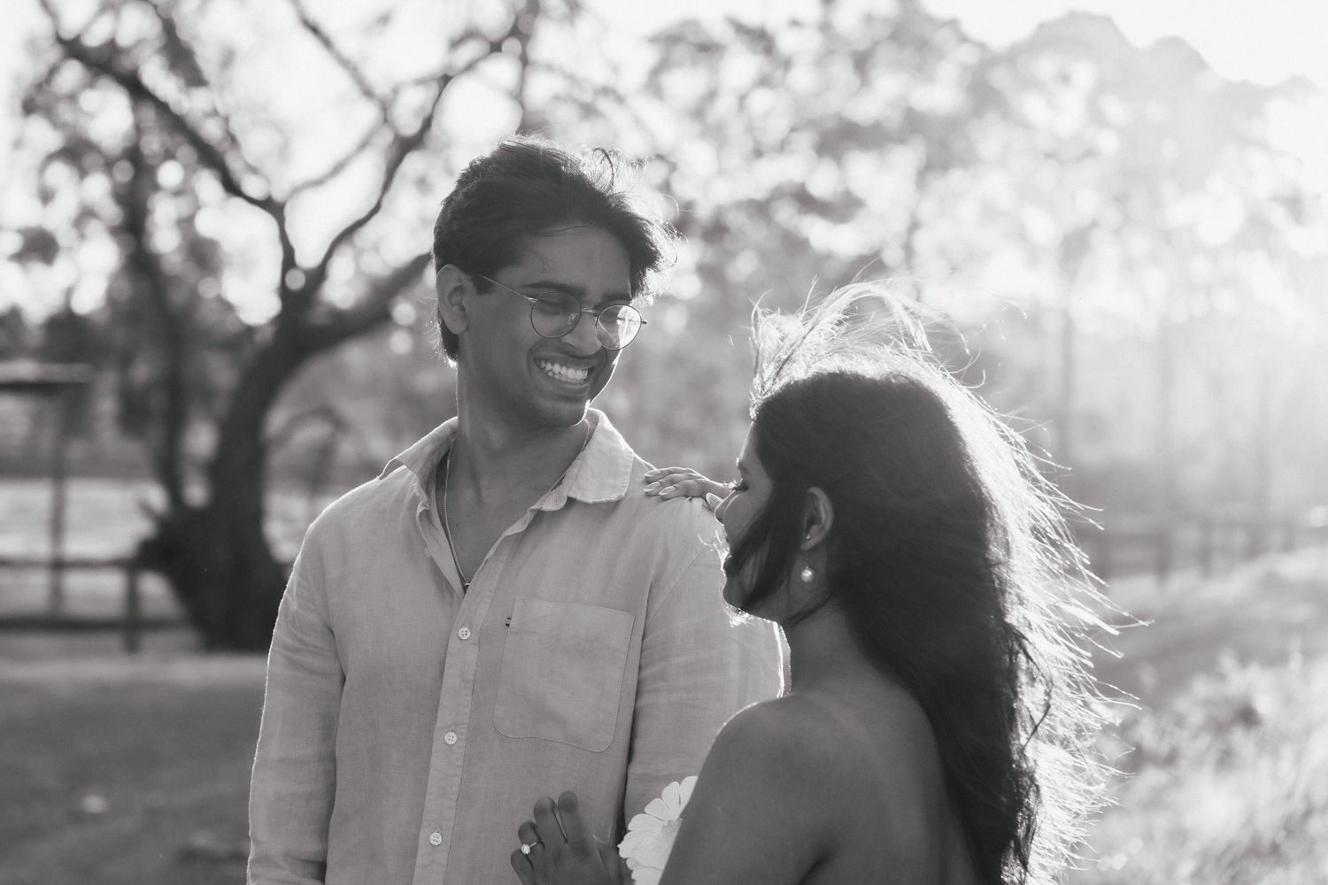 Couple sharing tender moments in a field during golden hour.