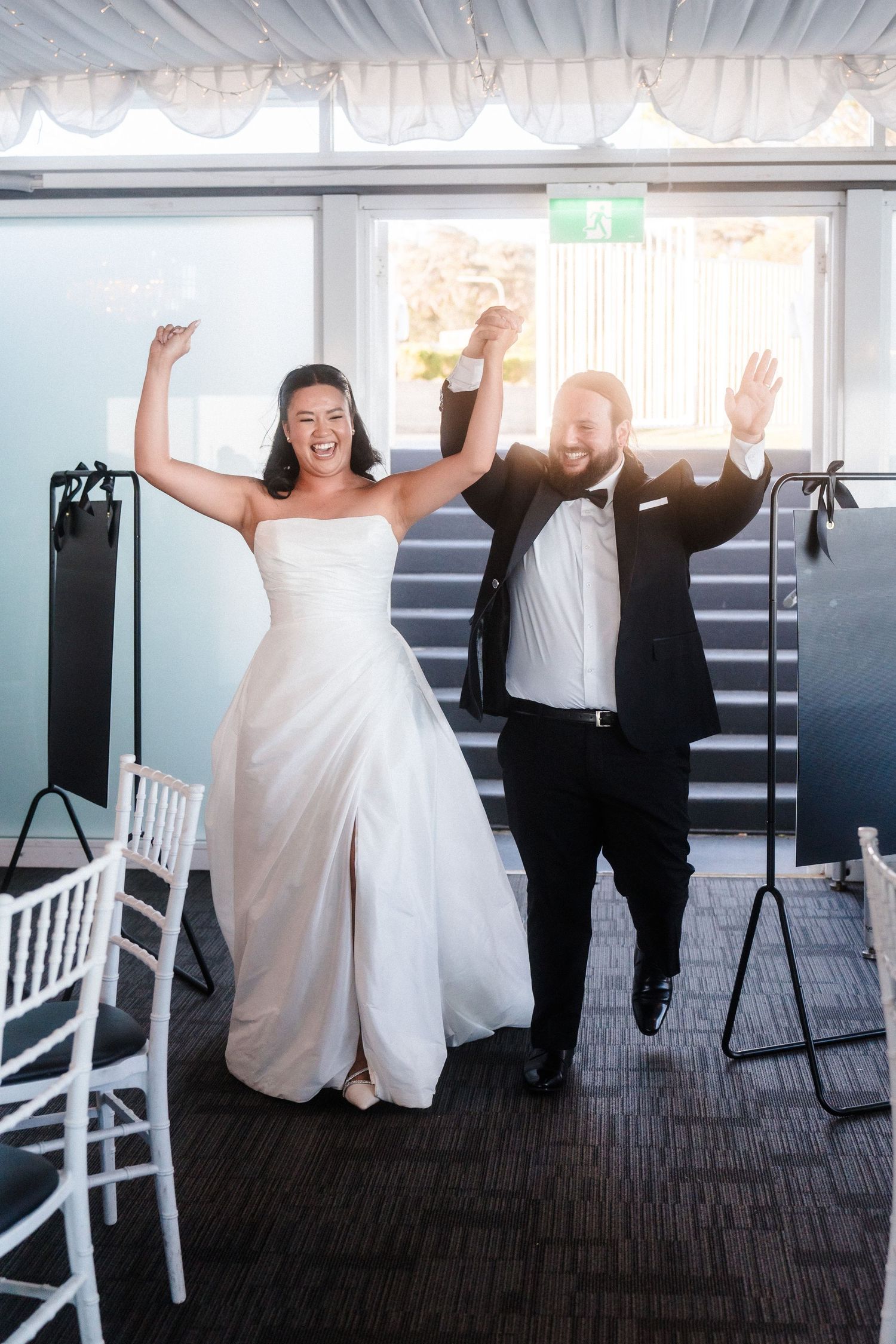 Wedding celebration with people jumping and celebrating in formal attire.