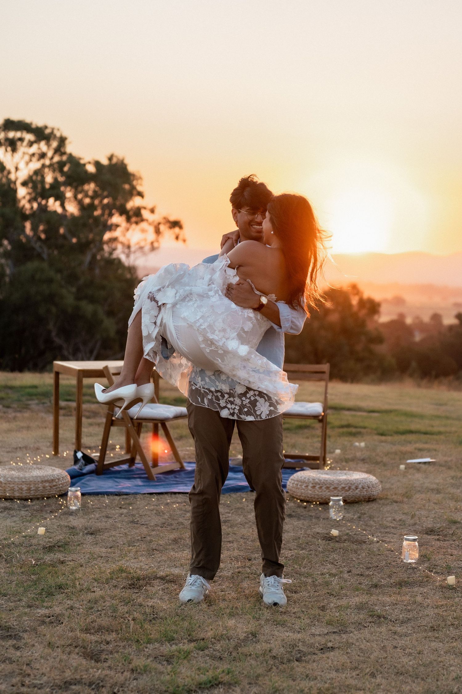 A couple recreates classic dance poses at sunset in a rustic outdoor setting.