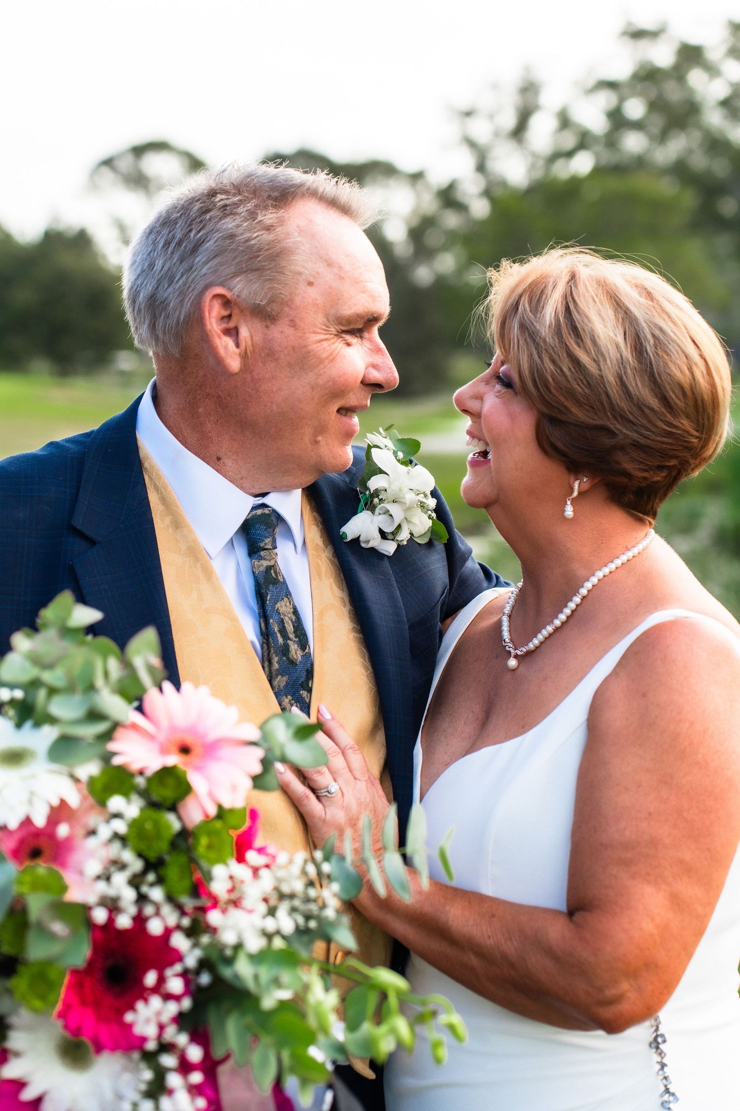 Wedding couple sharing romantic moments with colorful floral bouquet.