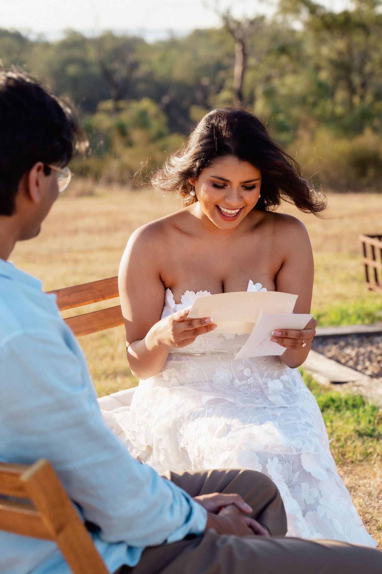 A couple sharing emotional moments while reading letters outdoors.