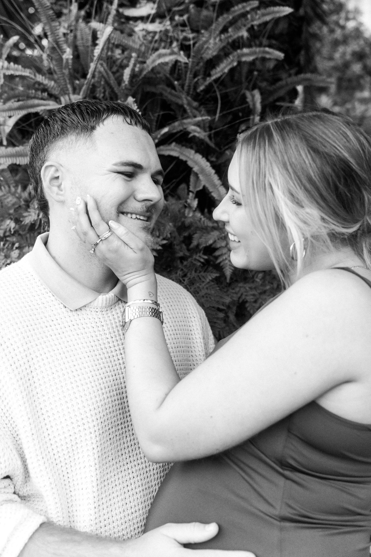 A romantic black and white photo series showing a tender moment between a couple among foliage.
