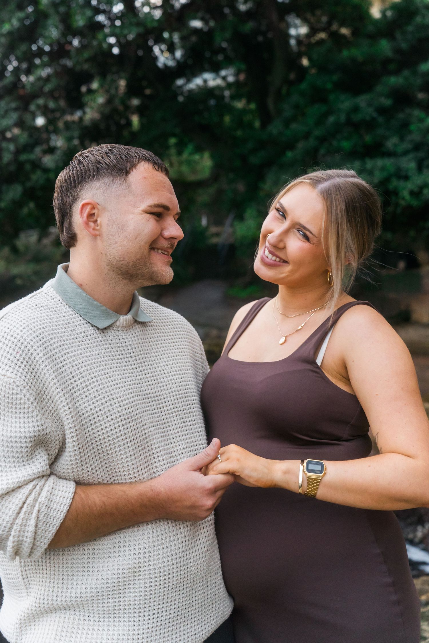 A joyful couple shares a loving moment in a garden setting.