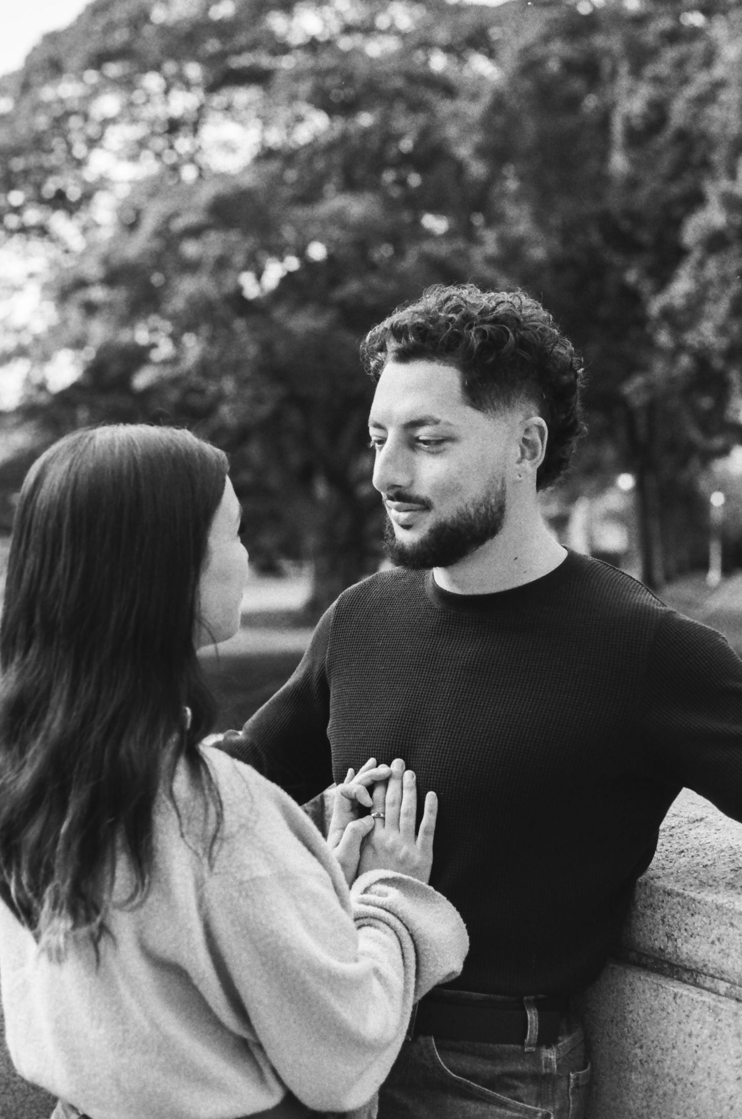 A couple shares tender moments in a black and white outdoor portrait series.