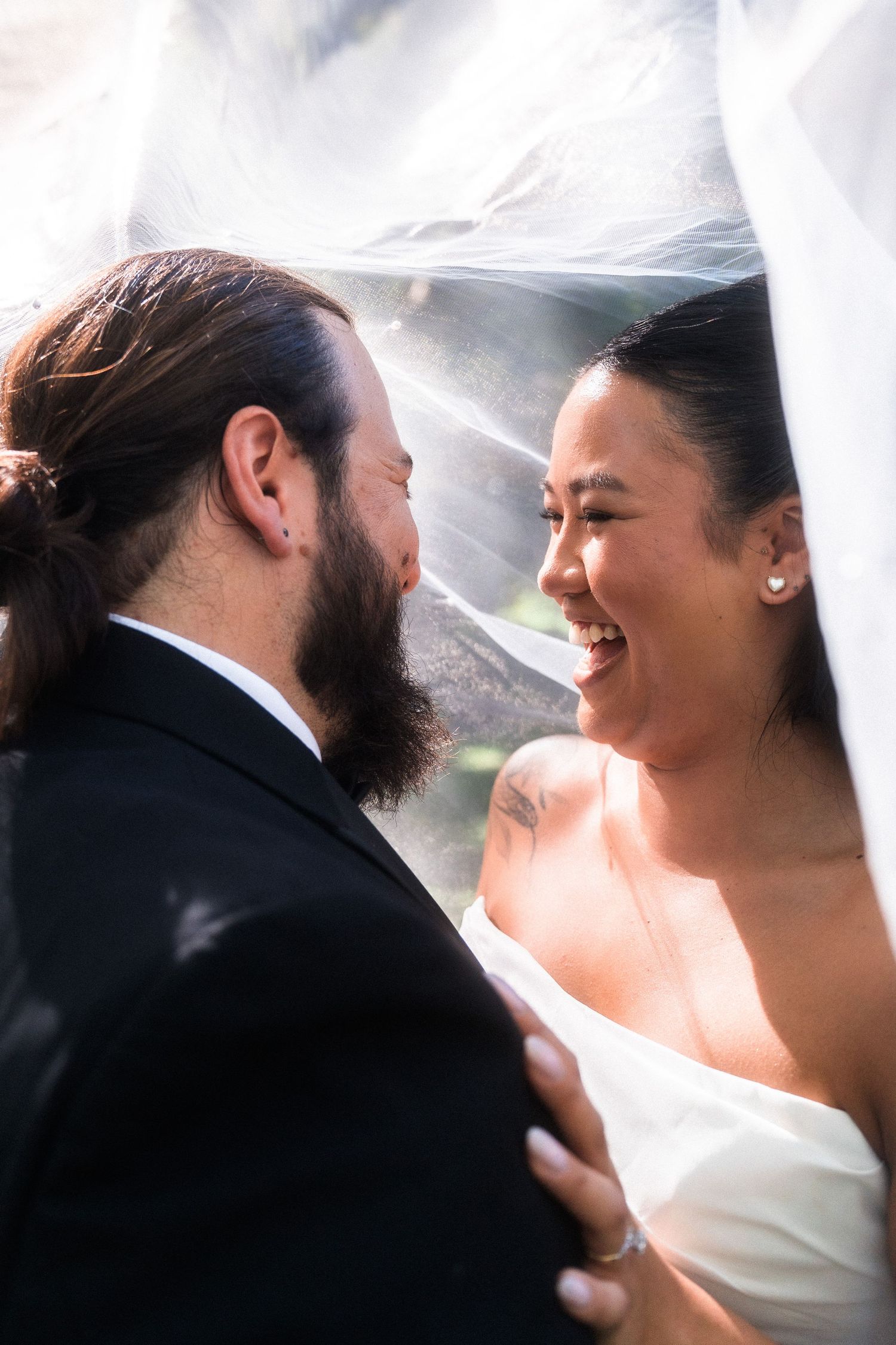 Romantic wedding portraits under a flowing white veil.