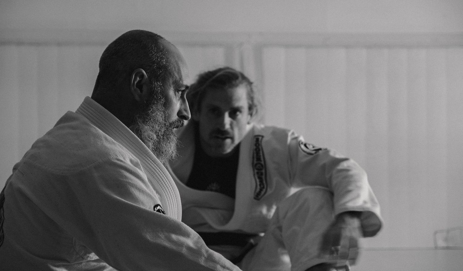 Two people in conversation while seated, captured in black and white photography.
