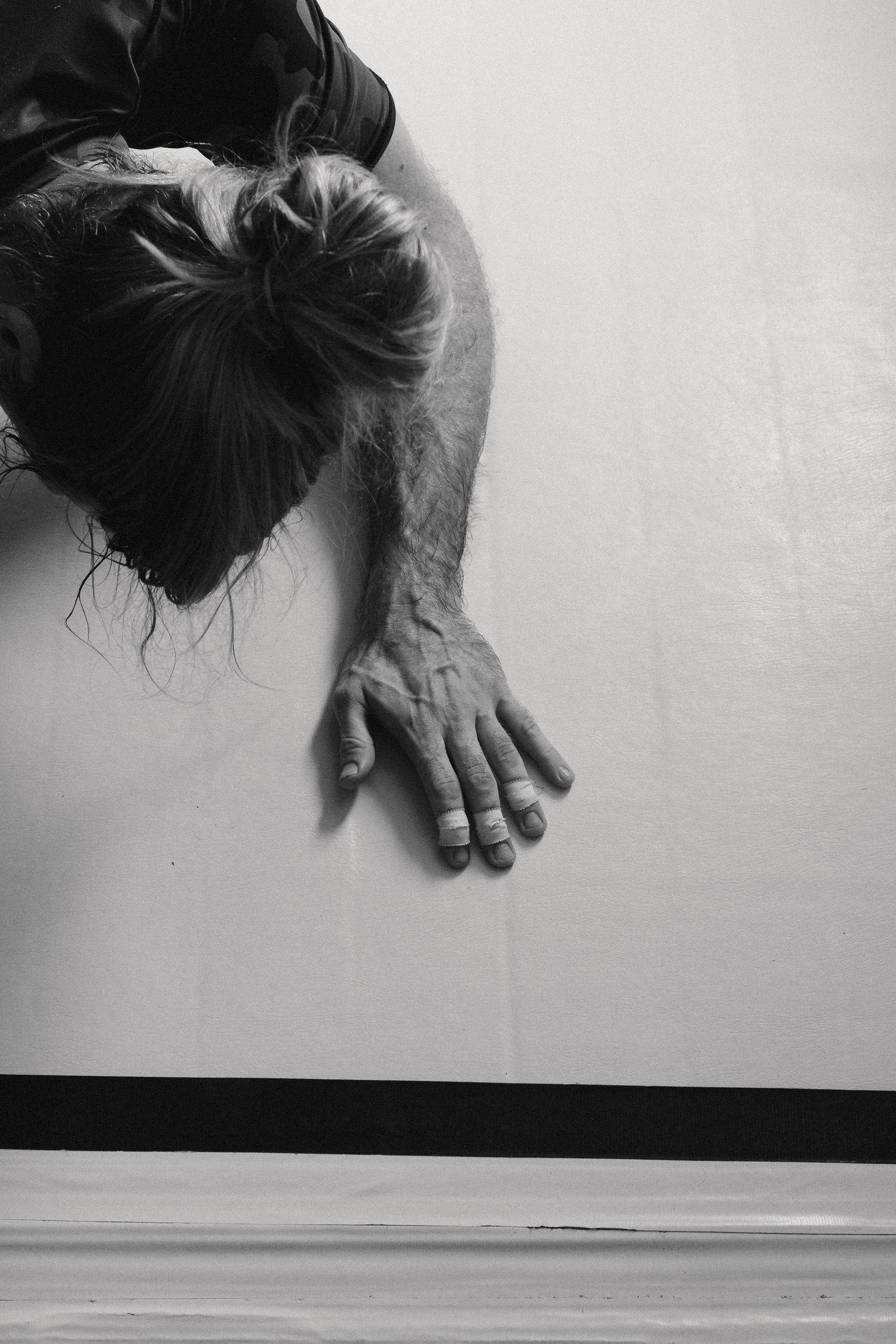 A black and white sequence of images showing a hand gradually descending against a minimalist background.