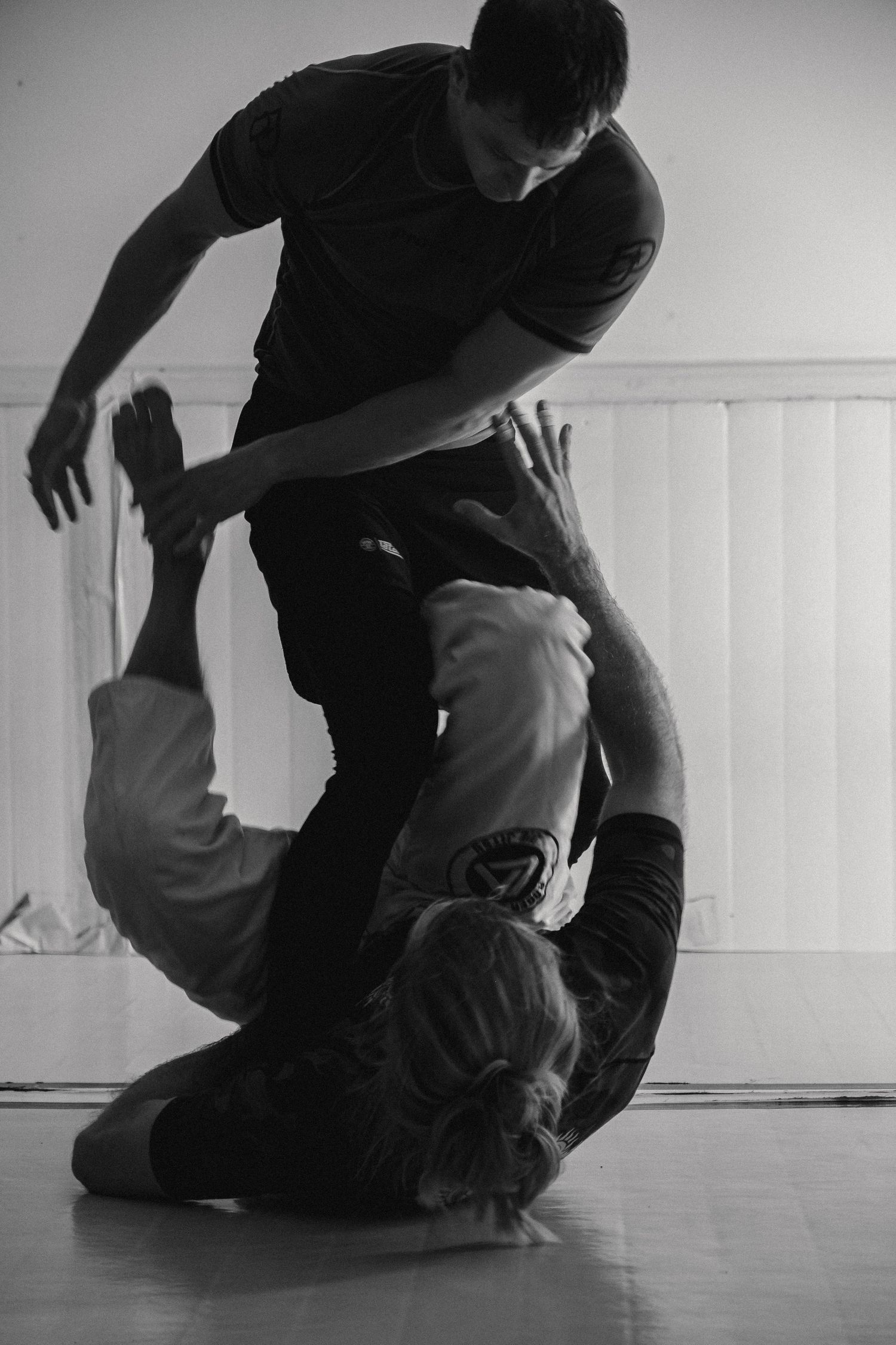 A black and white photo sequence shows a dancer performing floor movements in a minimalist studio space.