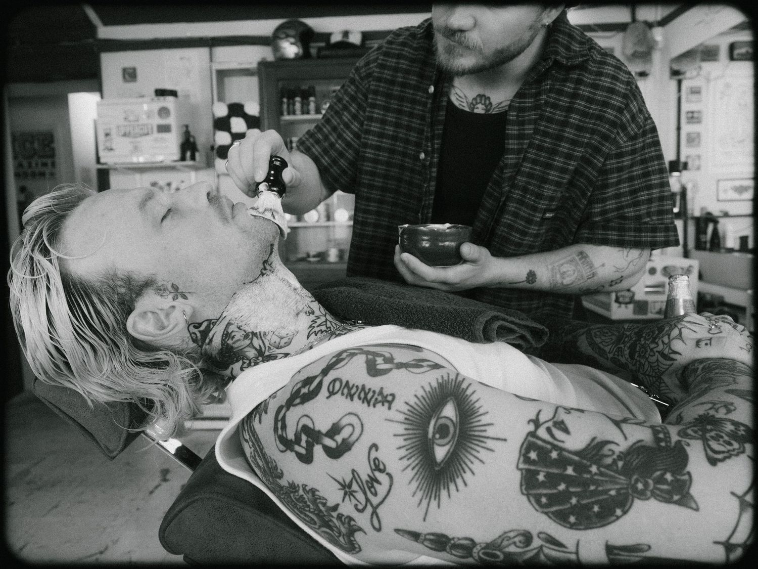 Black and white photo sequence showing the process of getting a large dragon tattoo across someone's back.