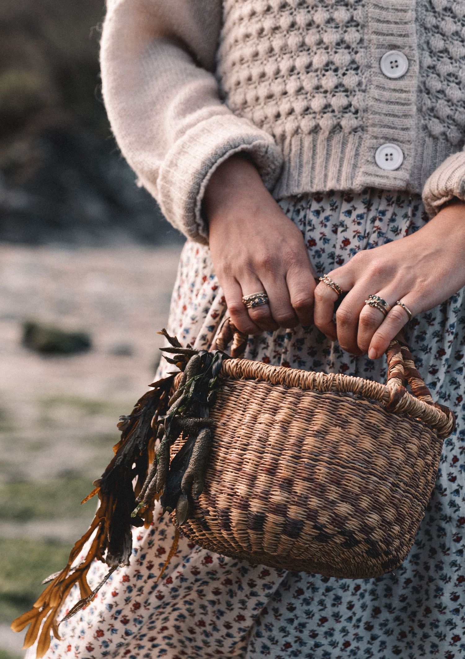 Hands holding a woven basket against a knit sweater background.