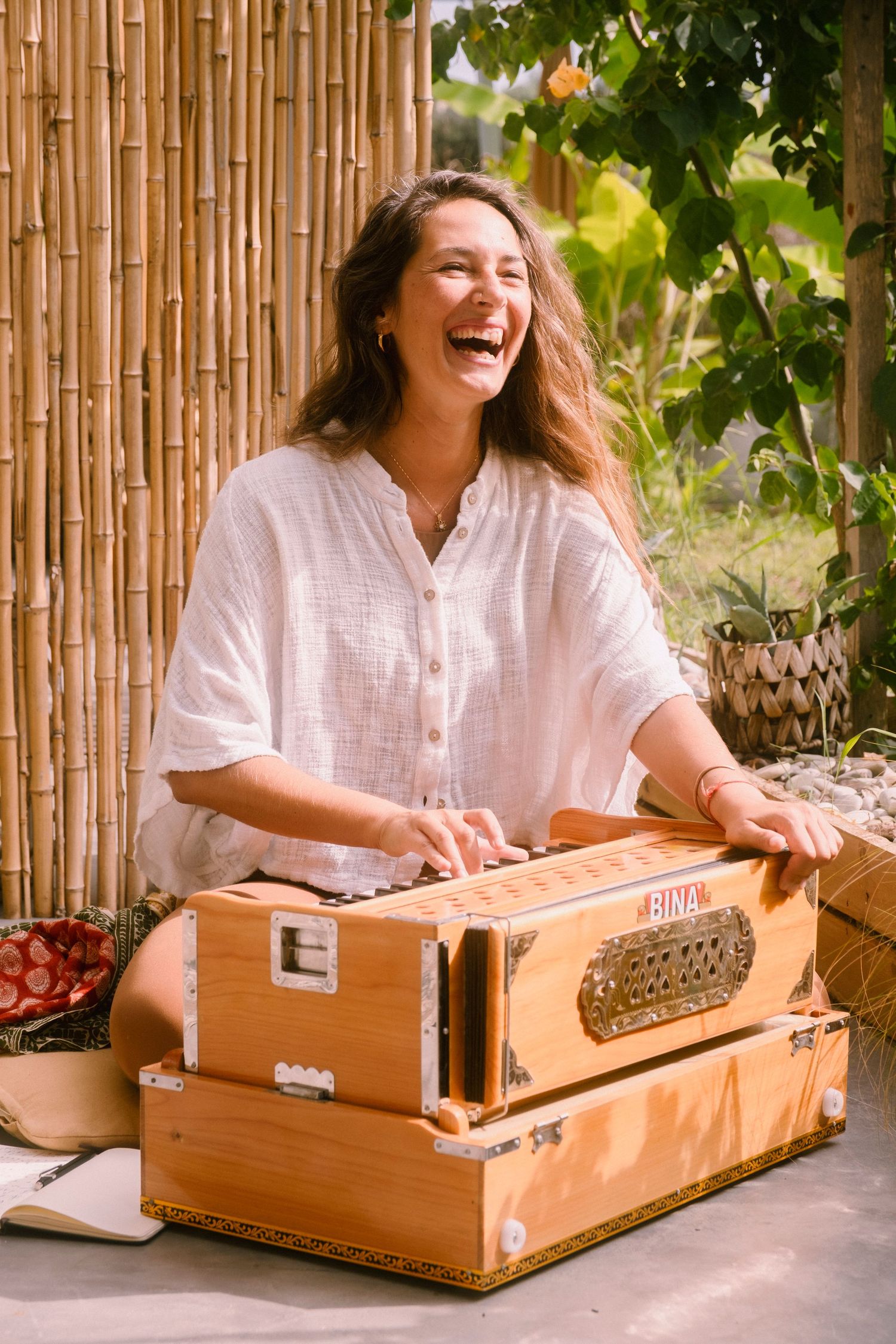 woman playing the harmonium in the garden of Inea Yoga in Corfu