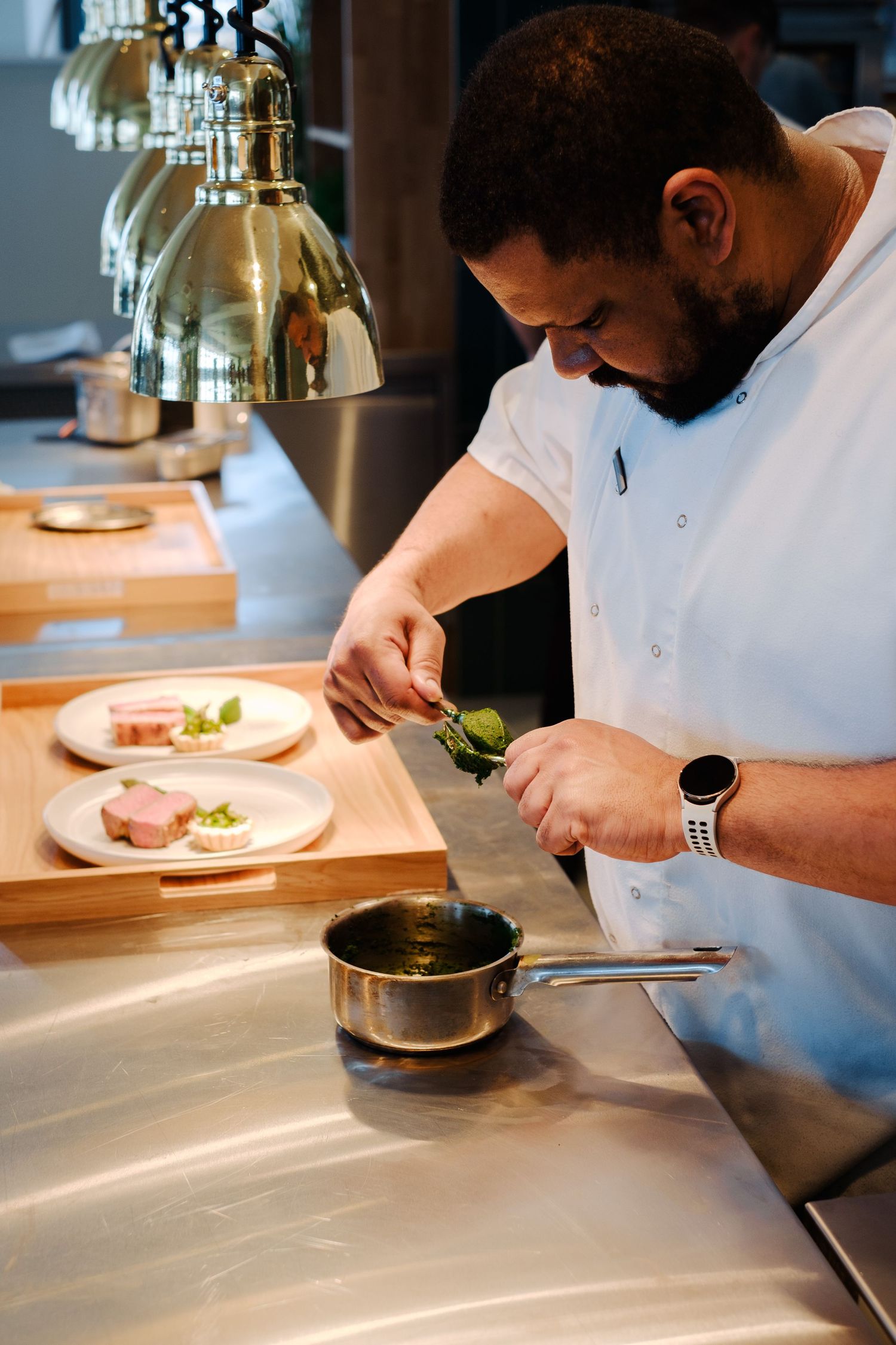 Chef carefully plating gourmet dishes in an upscale restaurant kitchen.