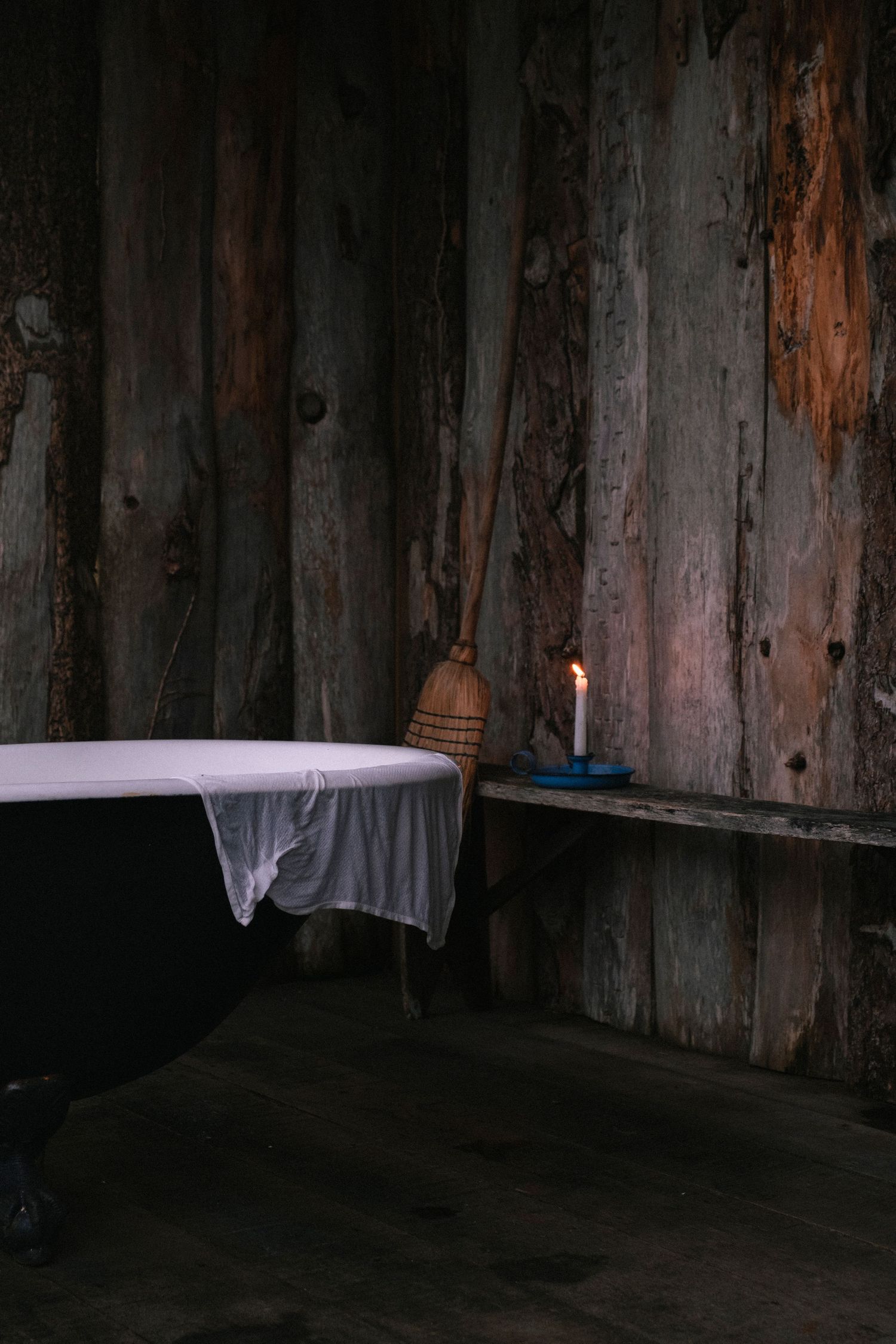Dark wooden wall with dim lighting creating moody shadows and textures.