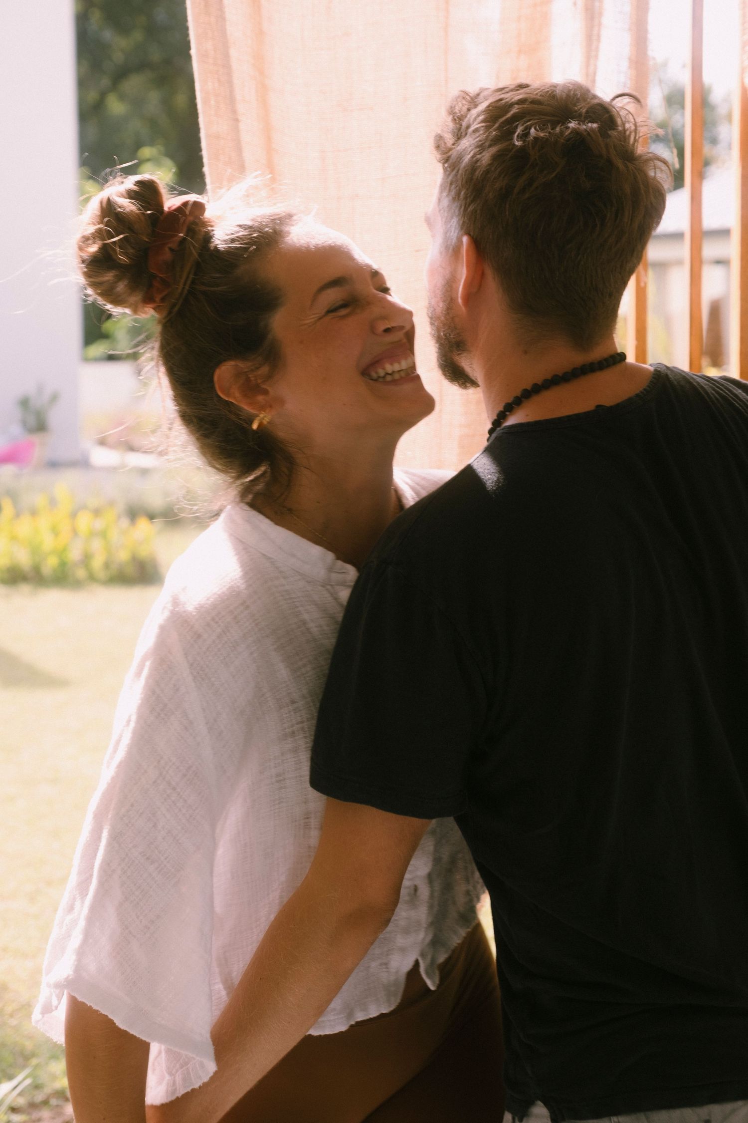 A couple shares an intimate laughing moment together in a series of candid photos.