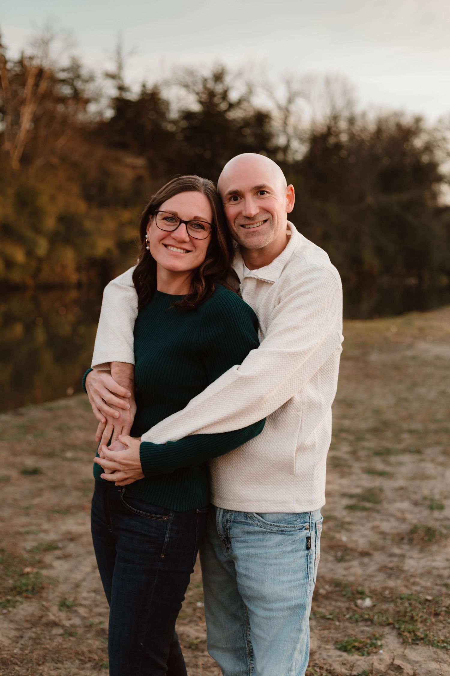 Couple hugging in grass field southeast minnesota