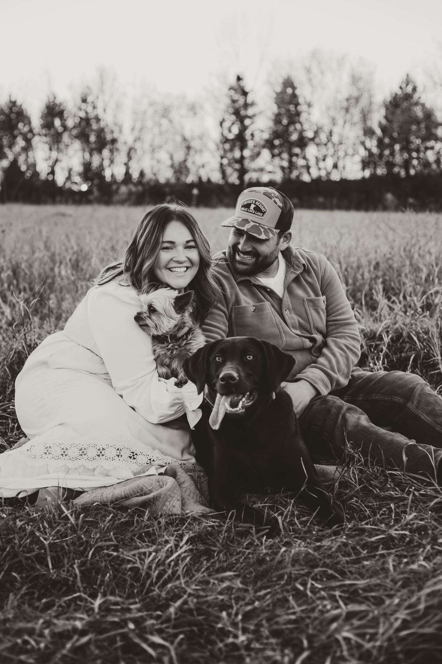 Couple cuddling dogs in grass field southeast minnesota