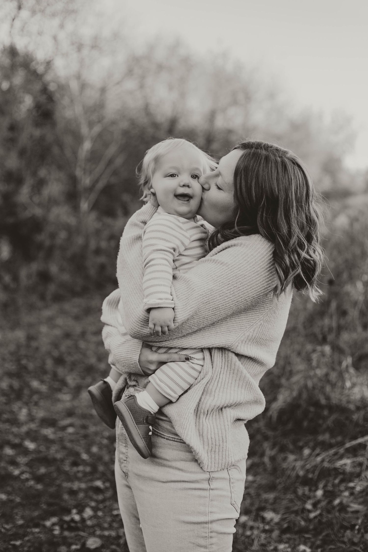 Mom kissing toddler in field in Southeast Minnesota