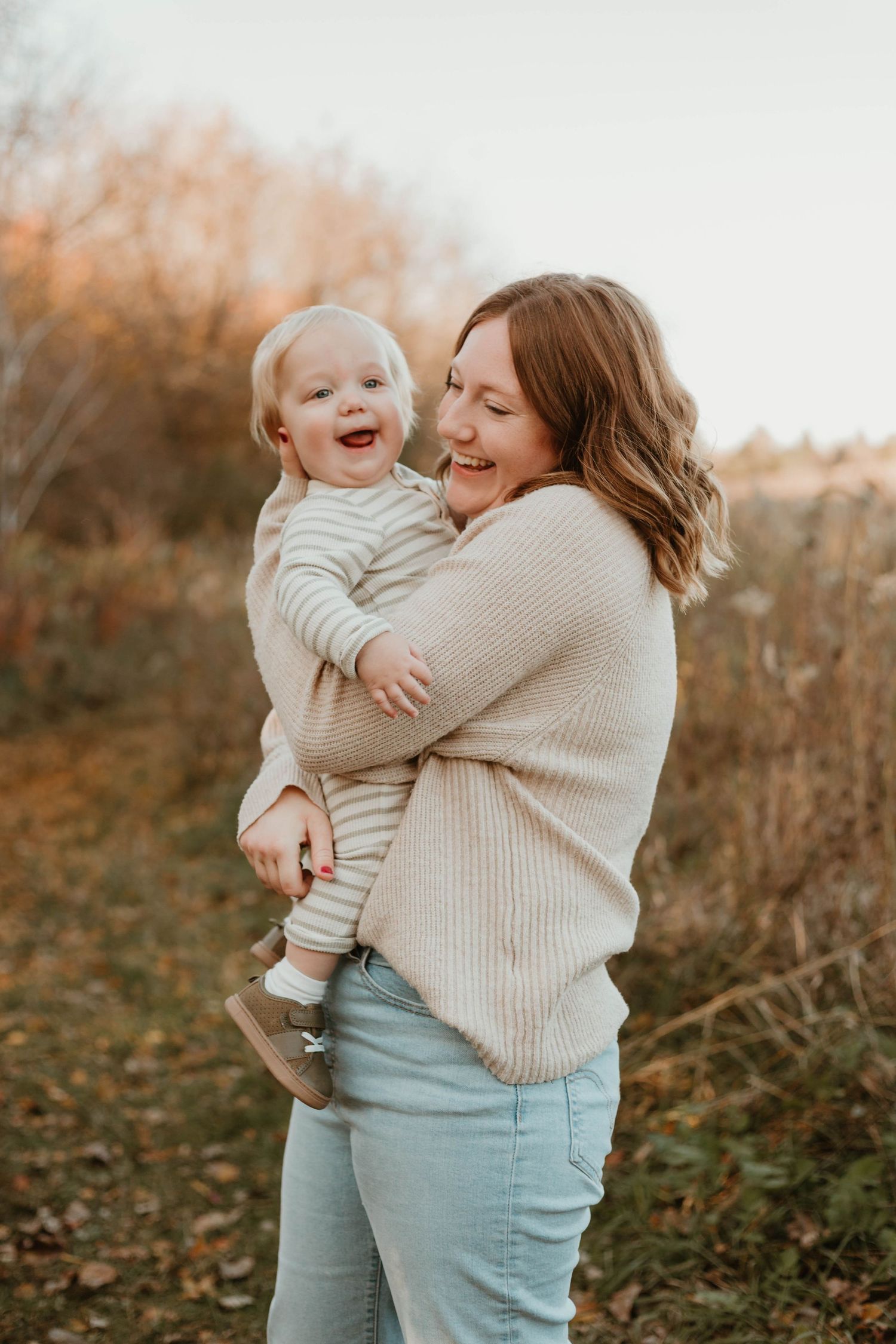 Mom and son hugging in grassy field Southeast Minnesota