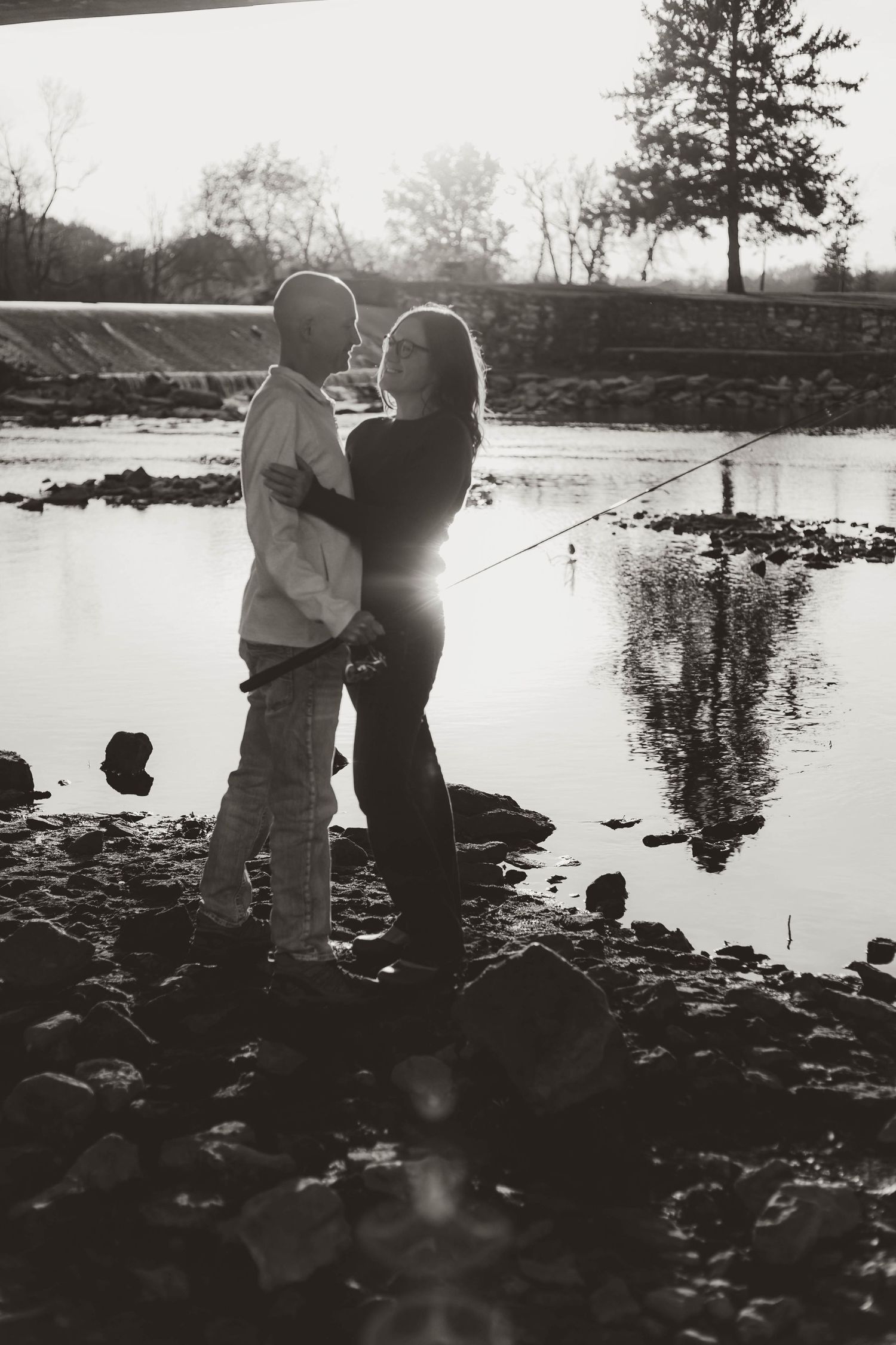 Couple fishing on river looking at each other southeast minnesota