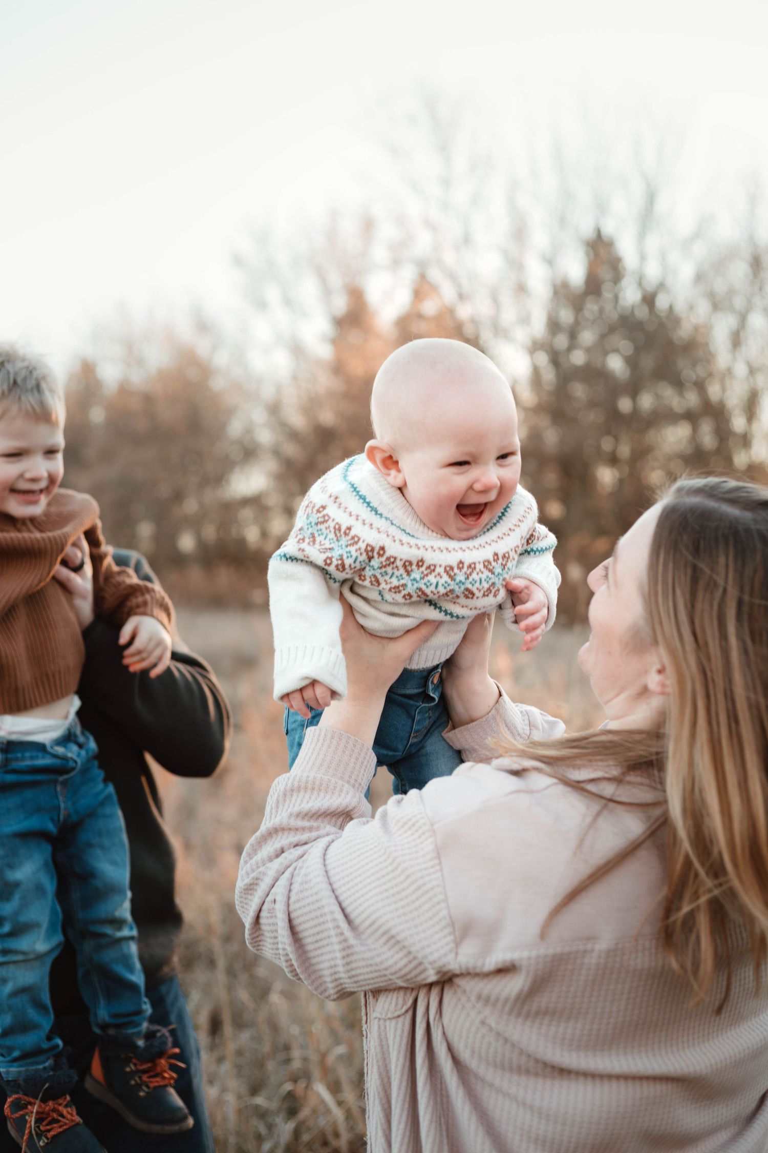 Family of 4 interacting in grassy field Southeast Minnesota